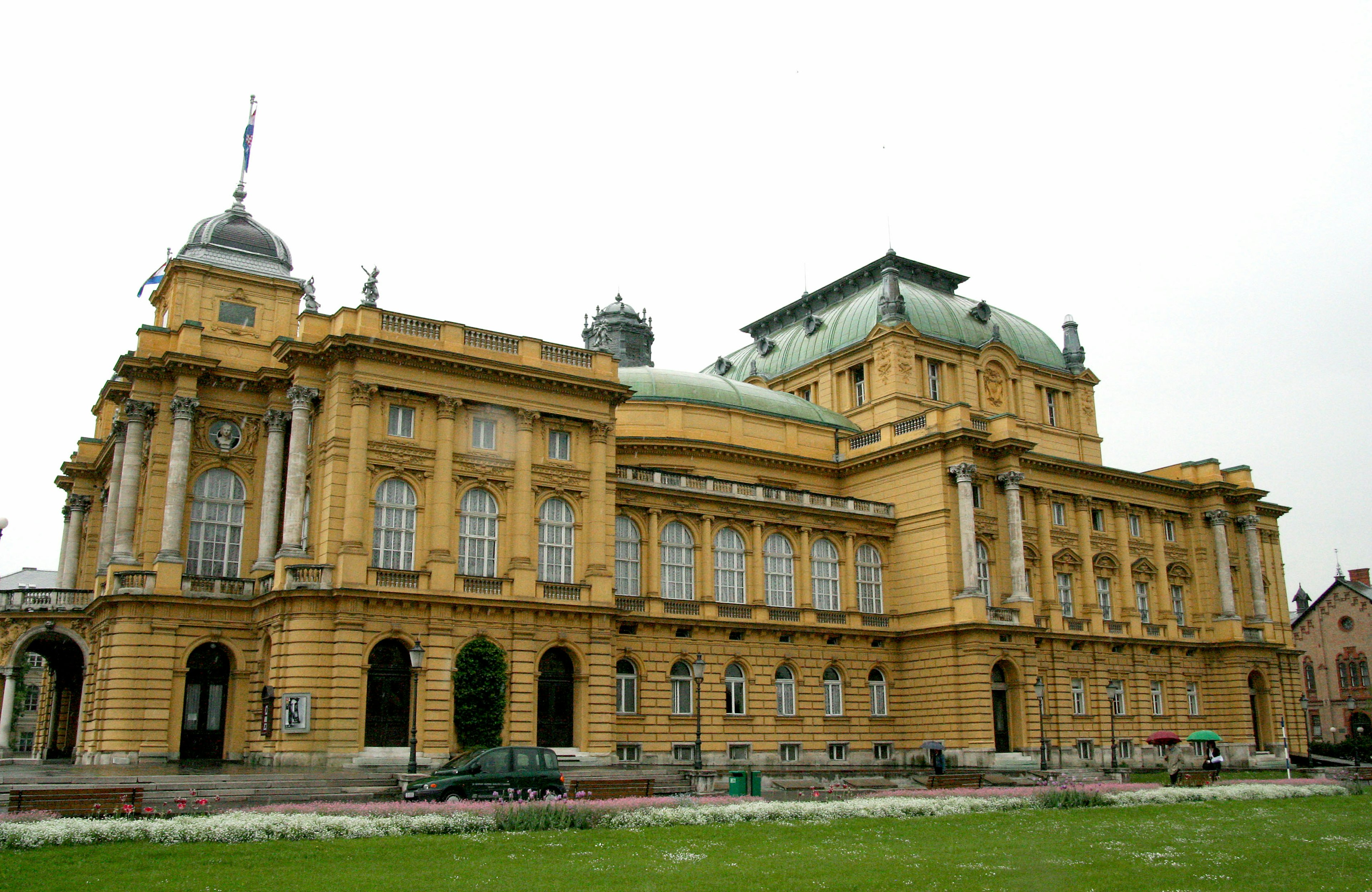 Außenansicht des historischen Opernhauses von Zagreb mit gelber Fassade und elegantem Kuppeldach