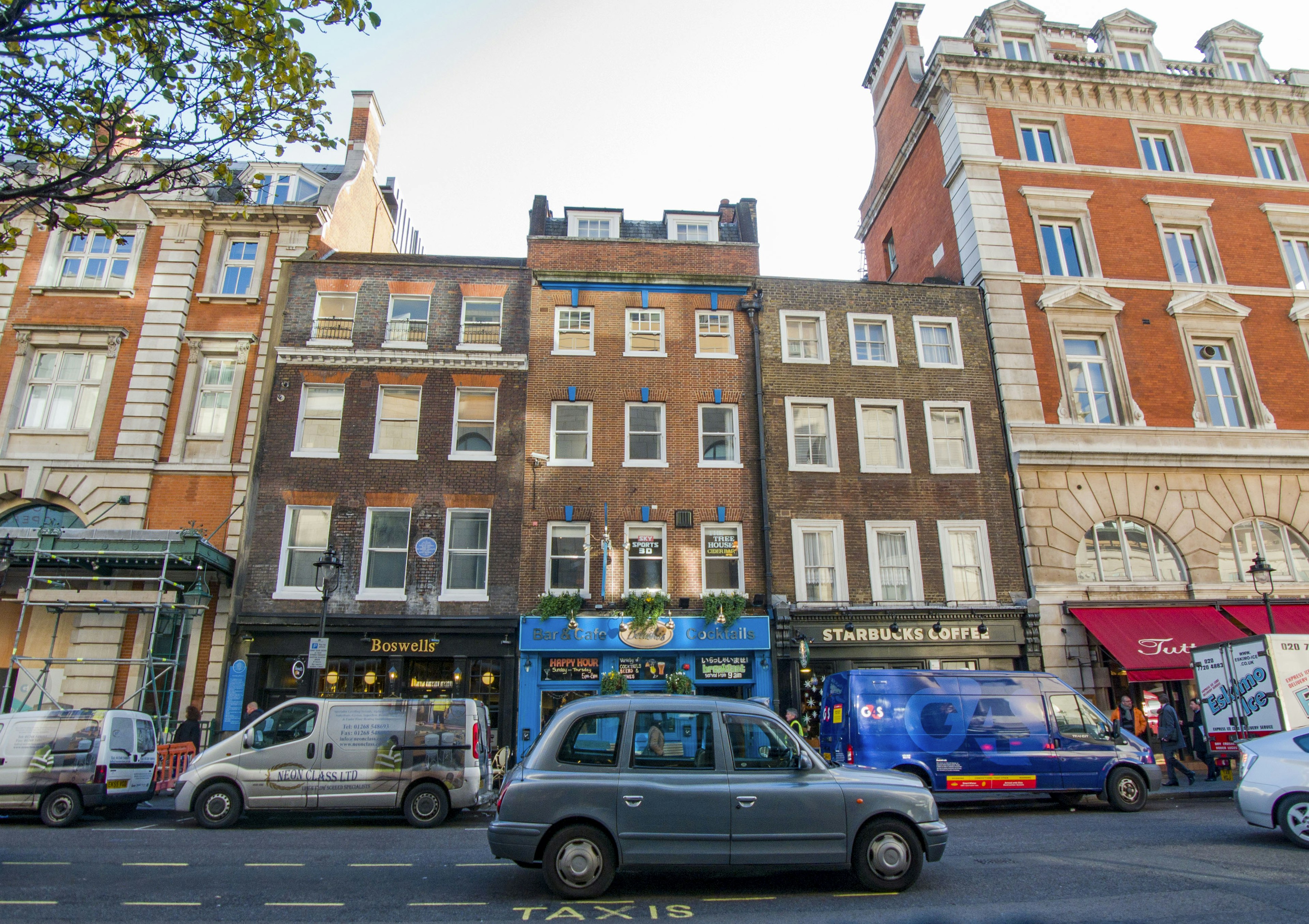 Vista de la calle en Londres con edificios históricos y vehículos modernos