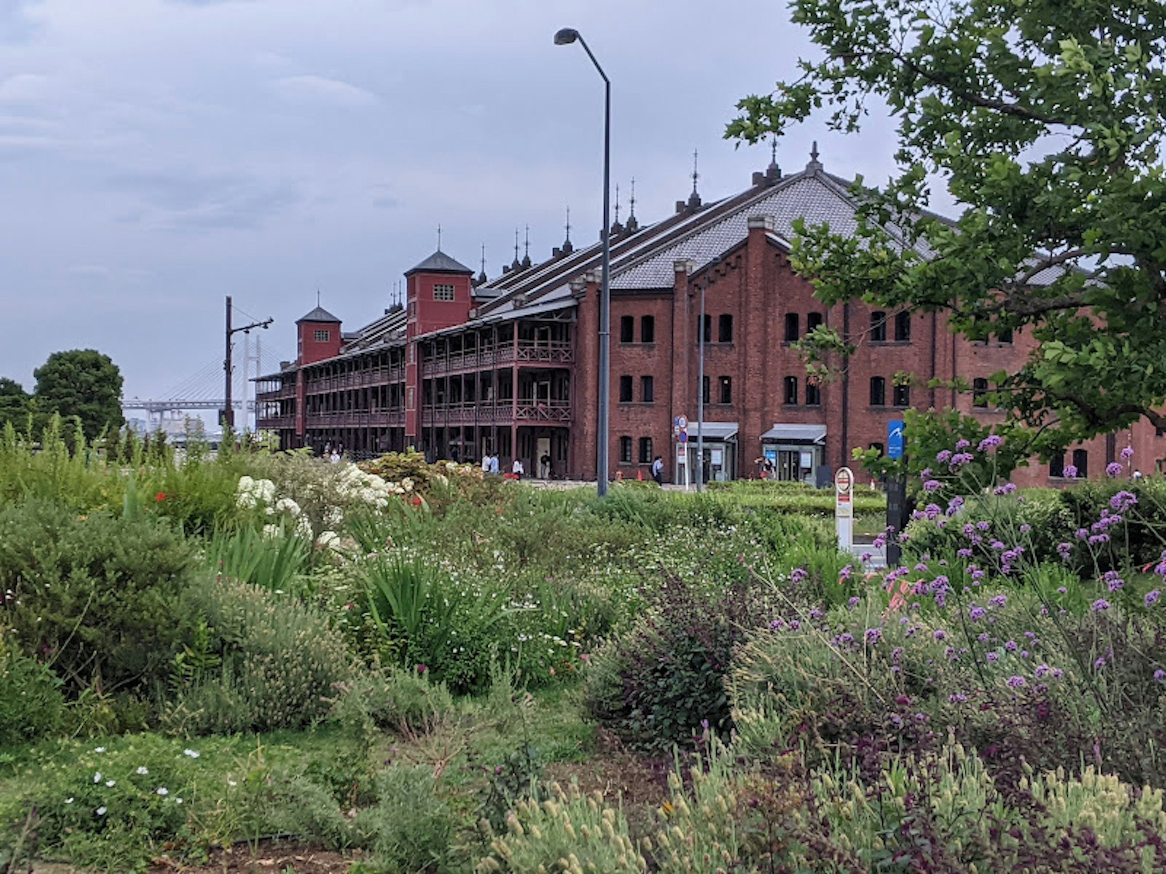 Red brick building with lush greenery in the foreground