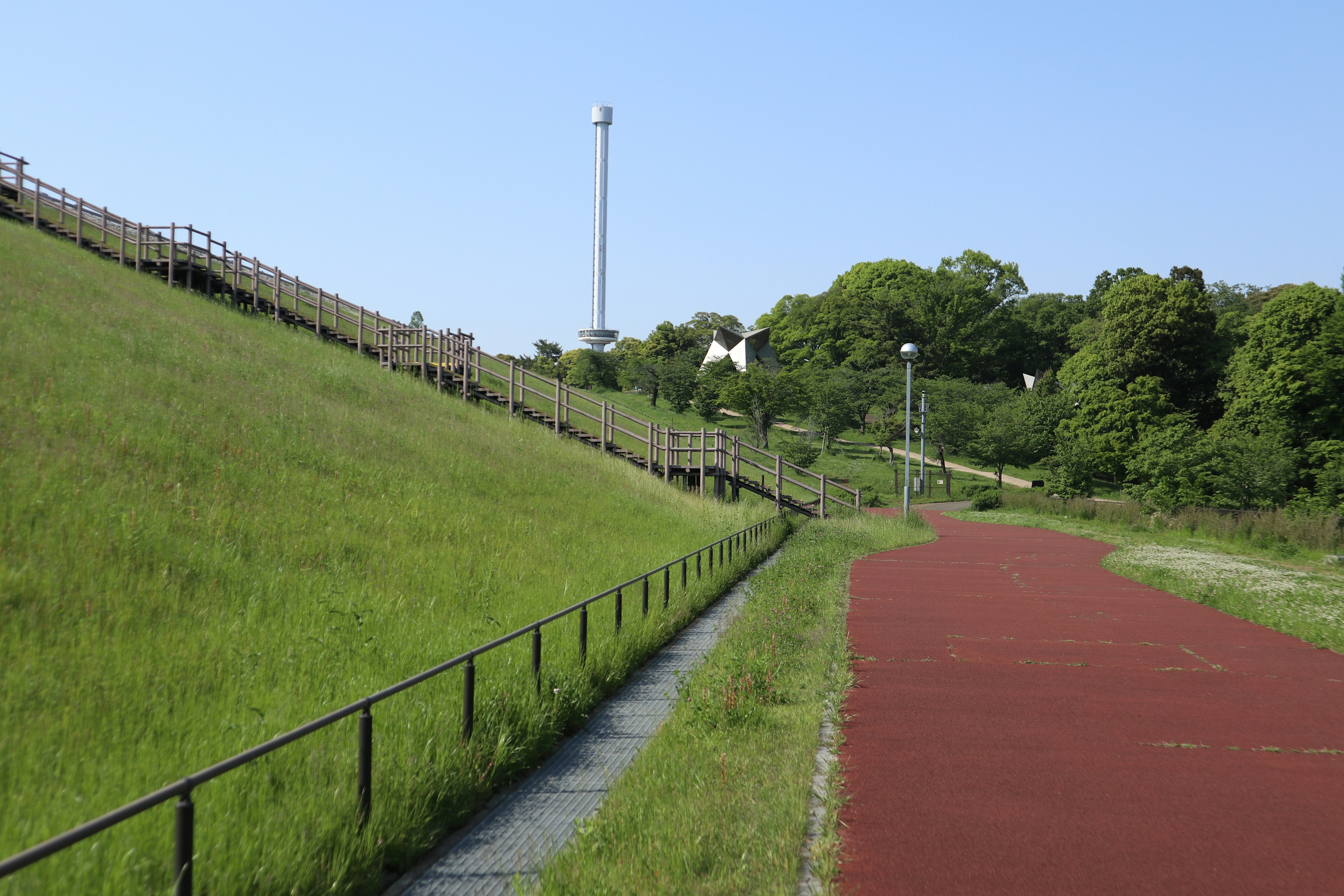 緑の草地と赤いトラックが見える公園の風景