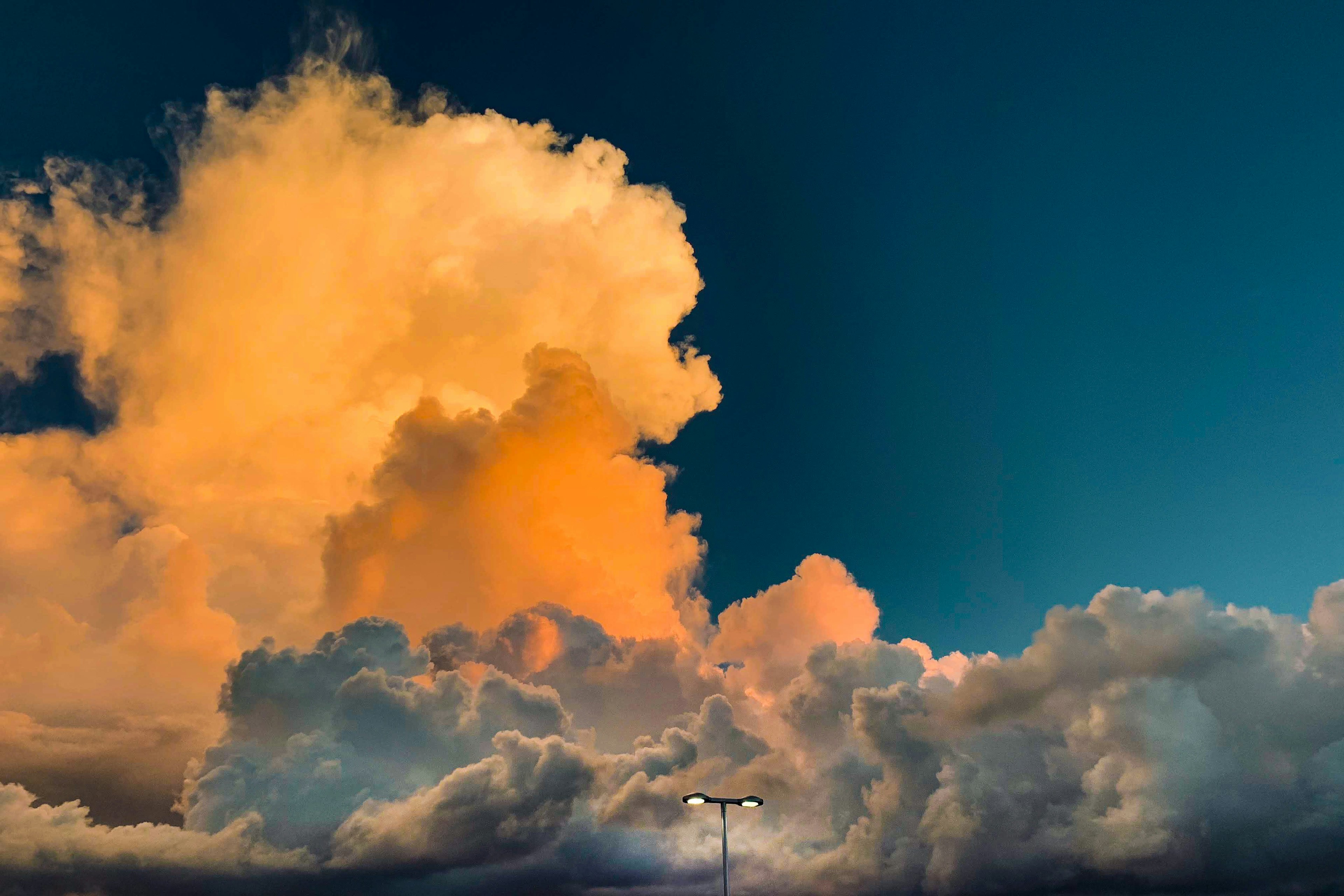 Contrast of orange and white clouds against a blue sky