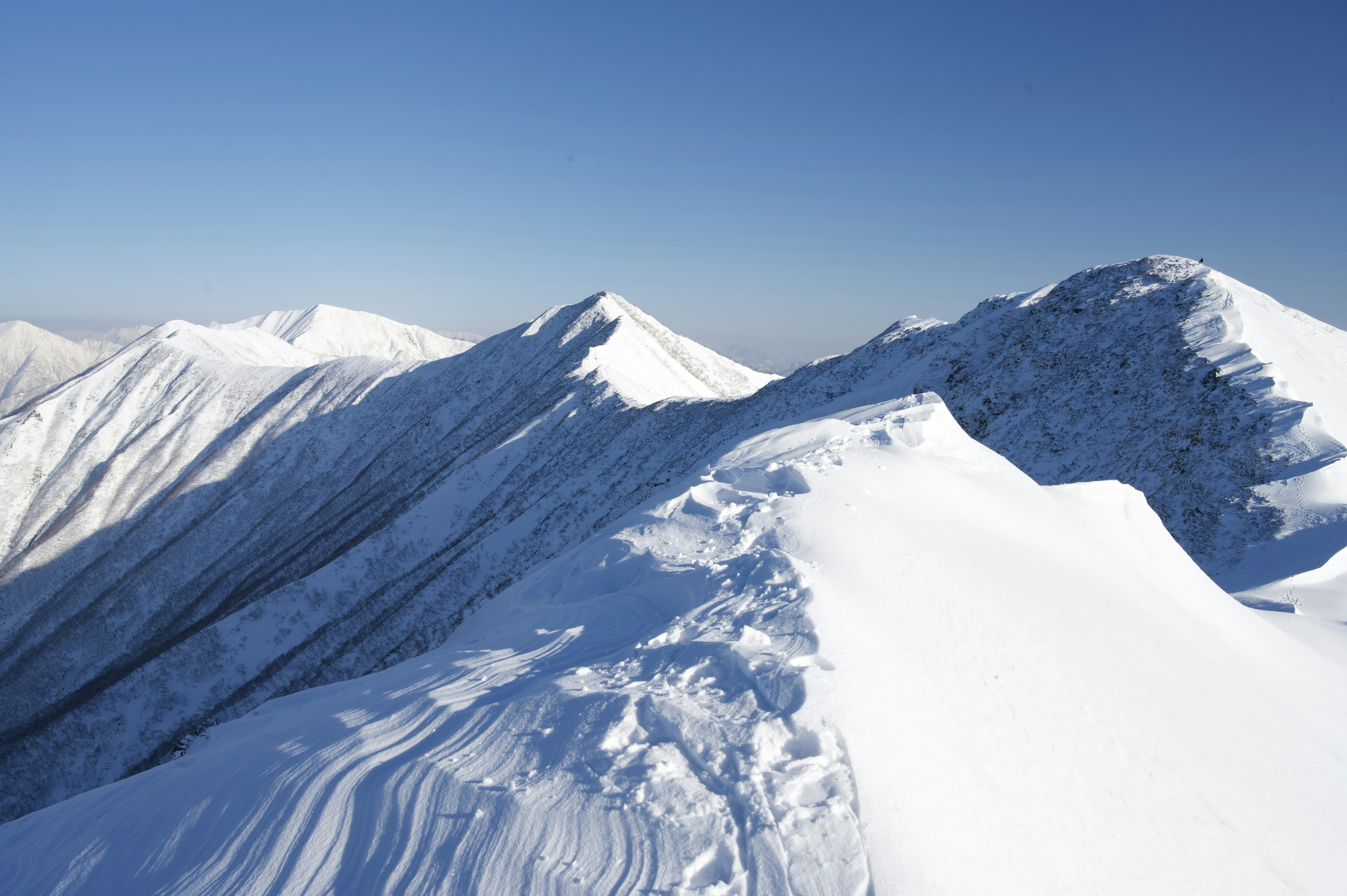 Cimes montagneuses enneigées sous un ciel bleu clair