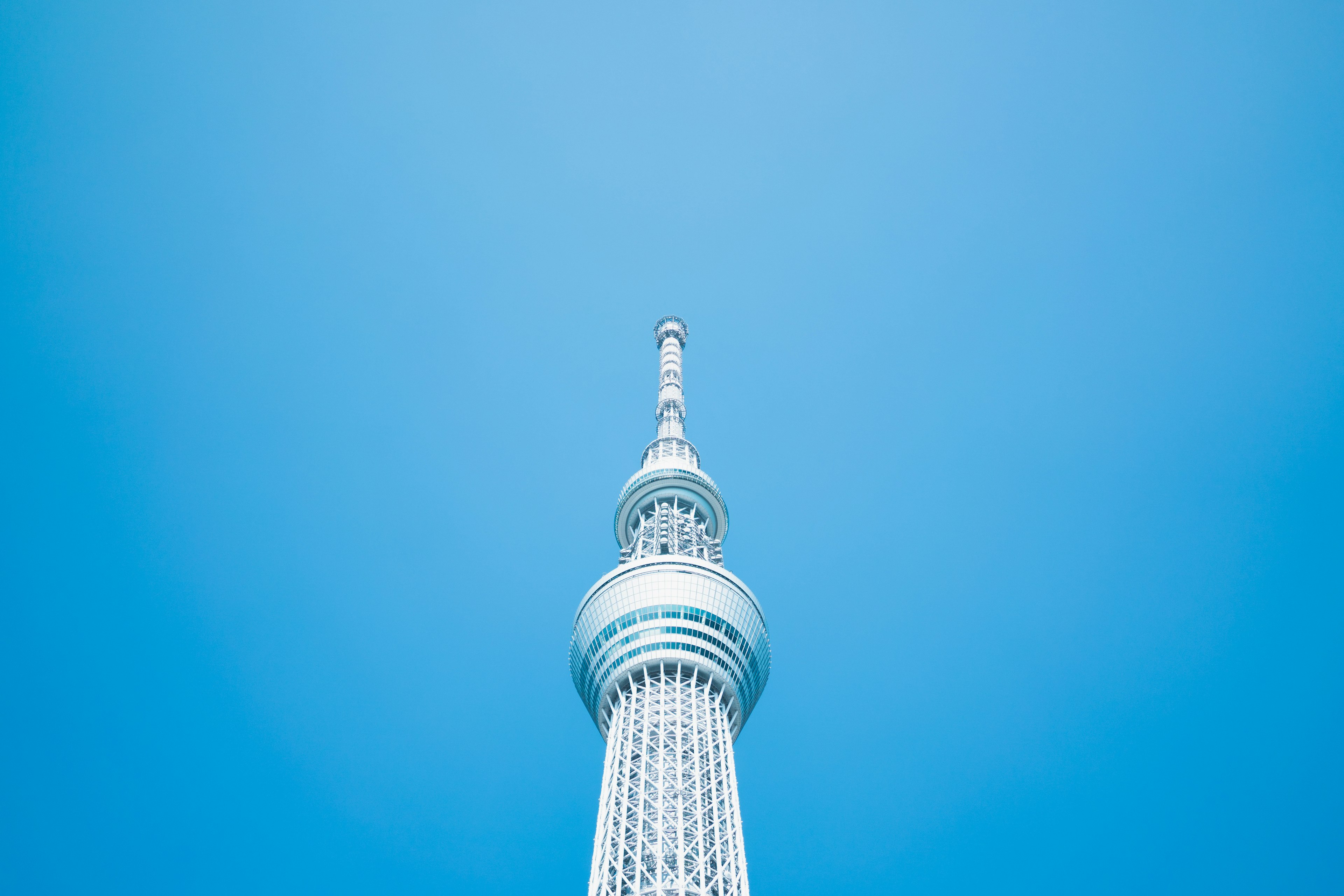 Cima della Tokyo Skytree che si erge contro un cielo blu chiaro