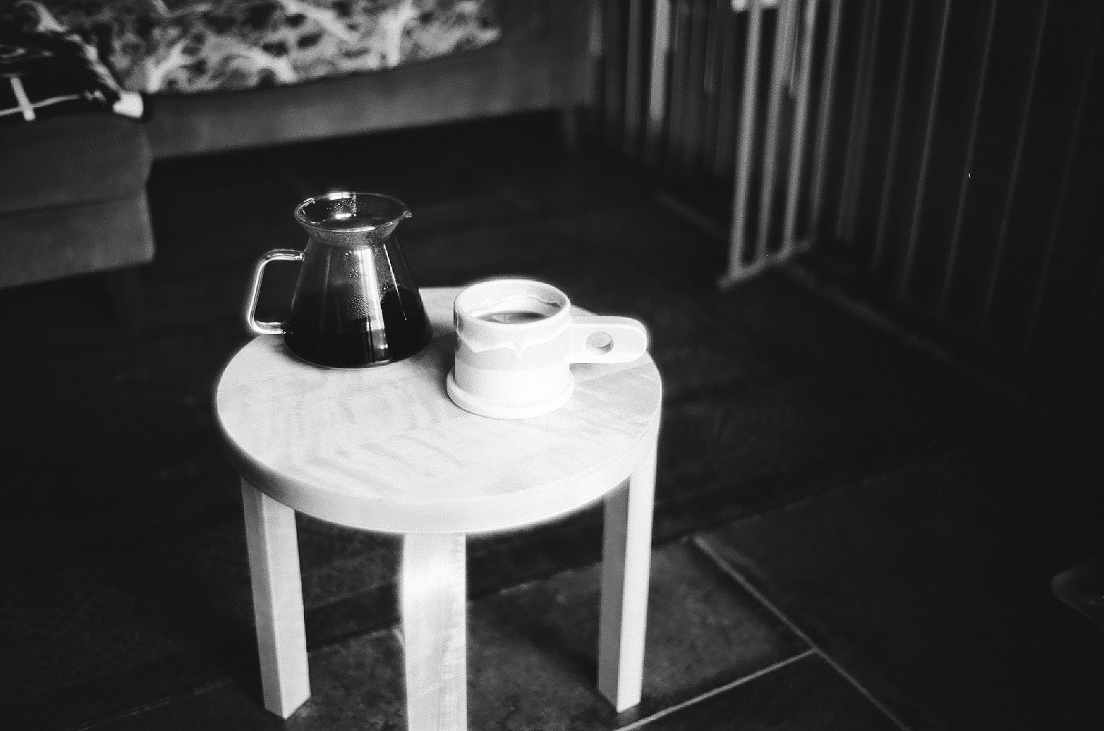 Tetera negra y blanca y taza blanca en una mesa redonda