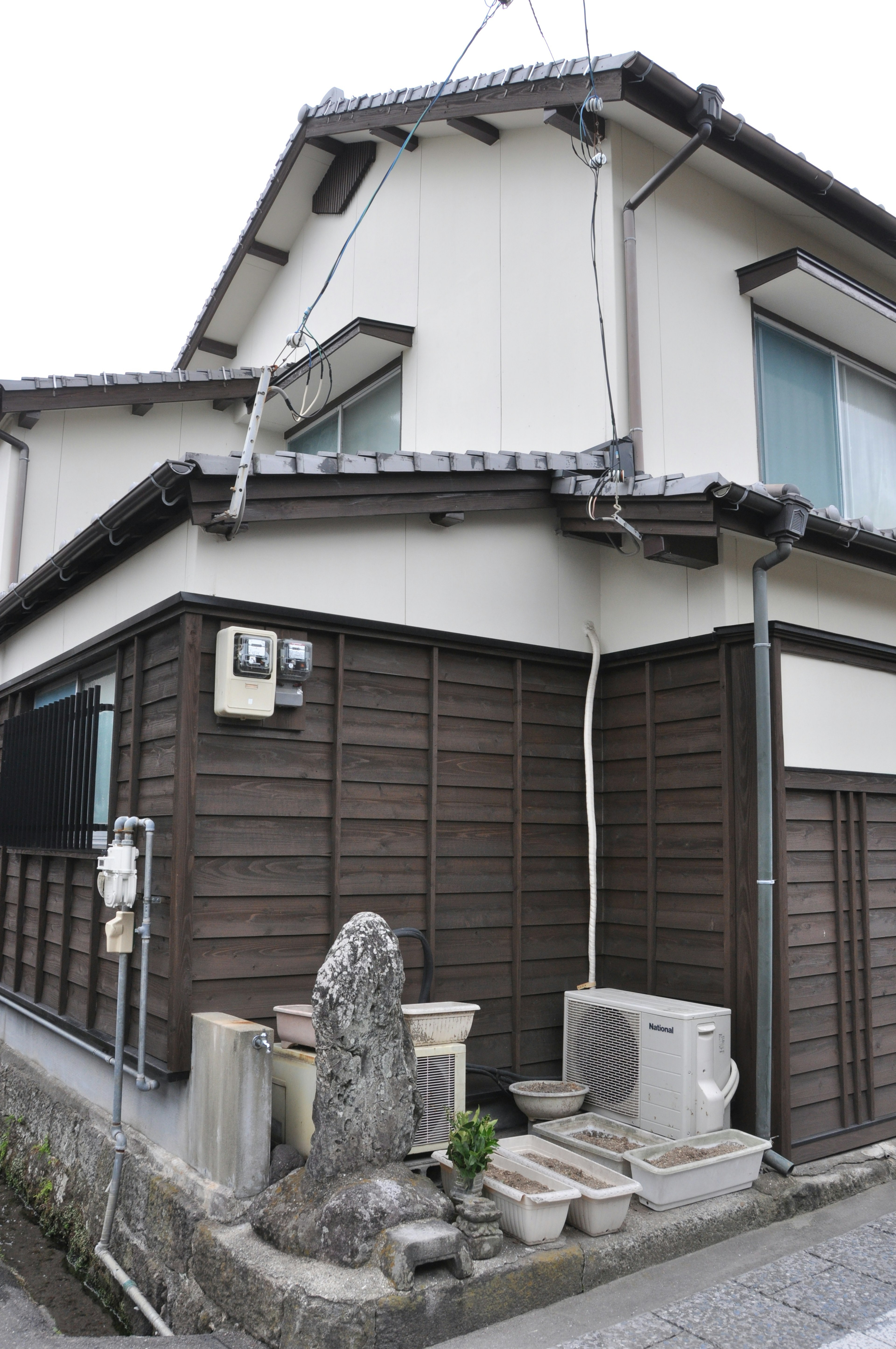 Extérieur d'une maison japonaise traditionnelle avec statue en pierre