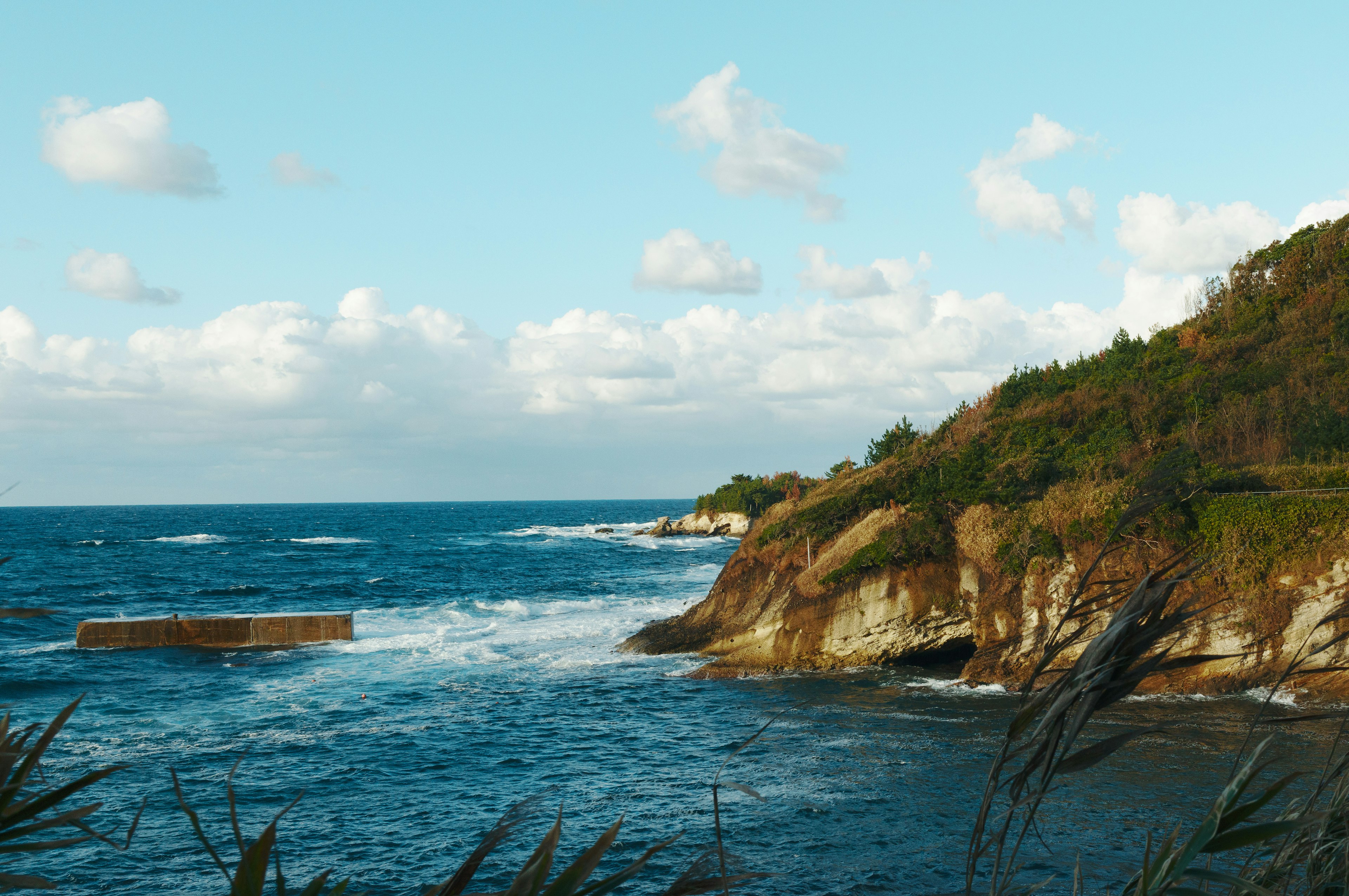 Pemandangan pantai yang indah dengan laut biru dan awan putih