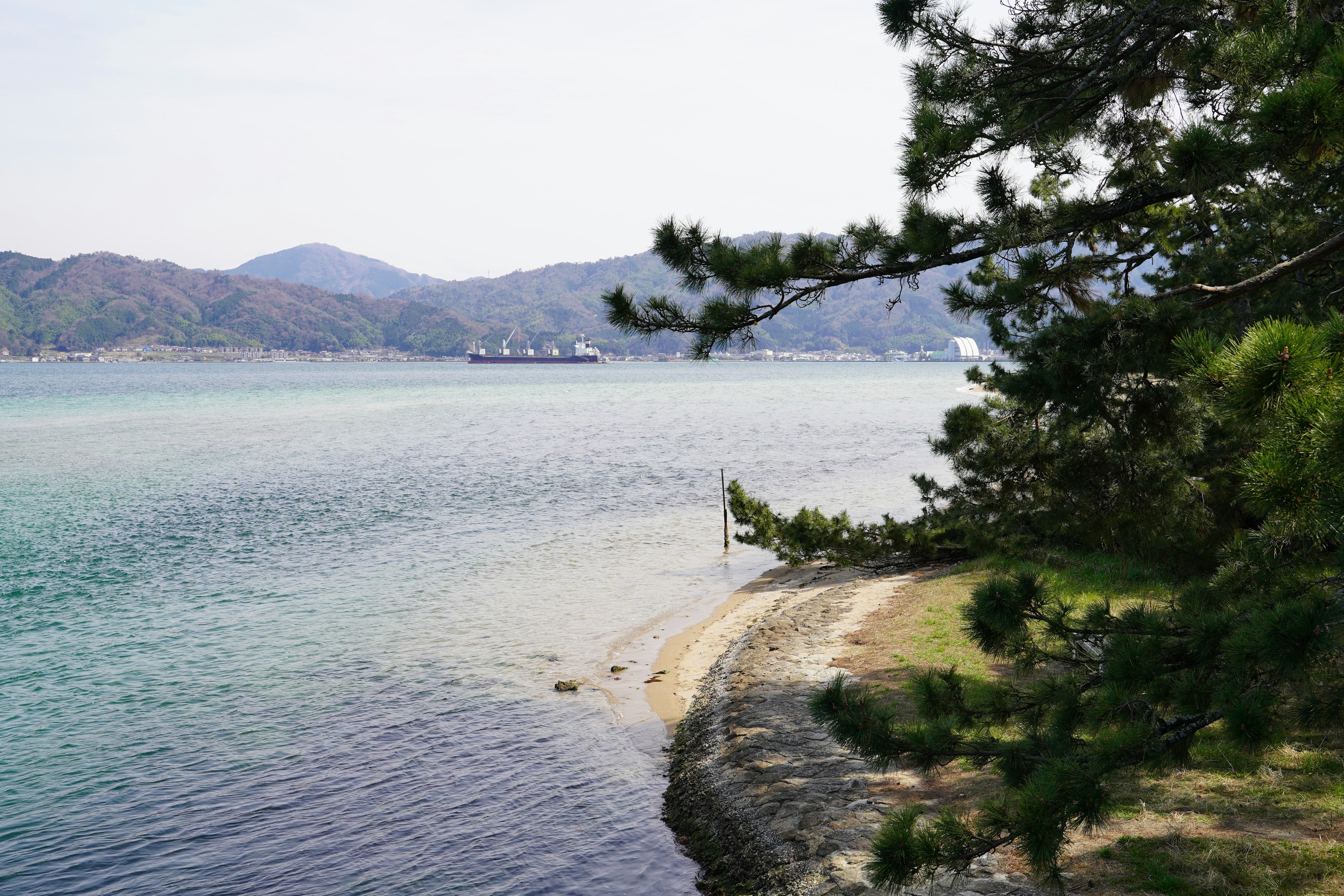 青い海と山々が見える静かな海岸の風景