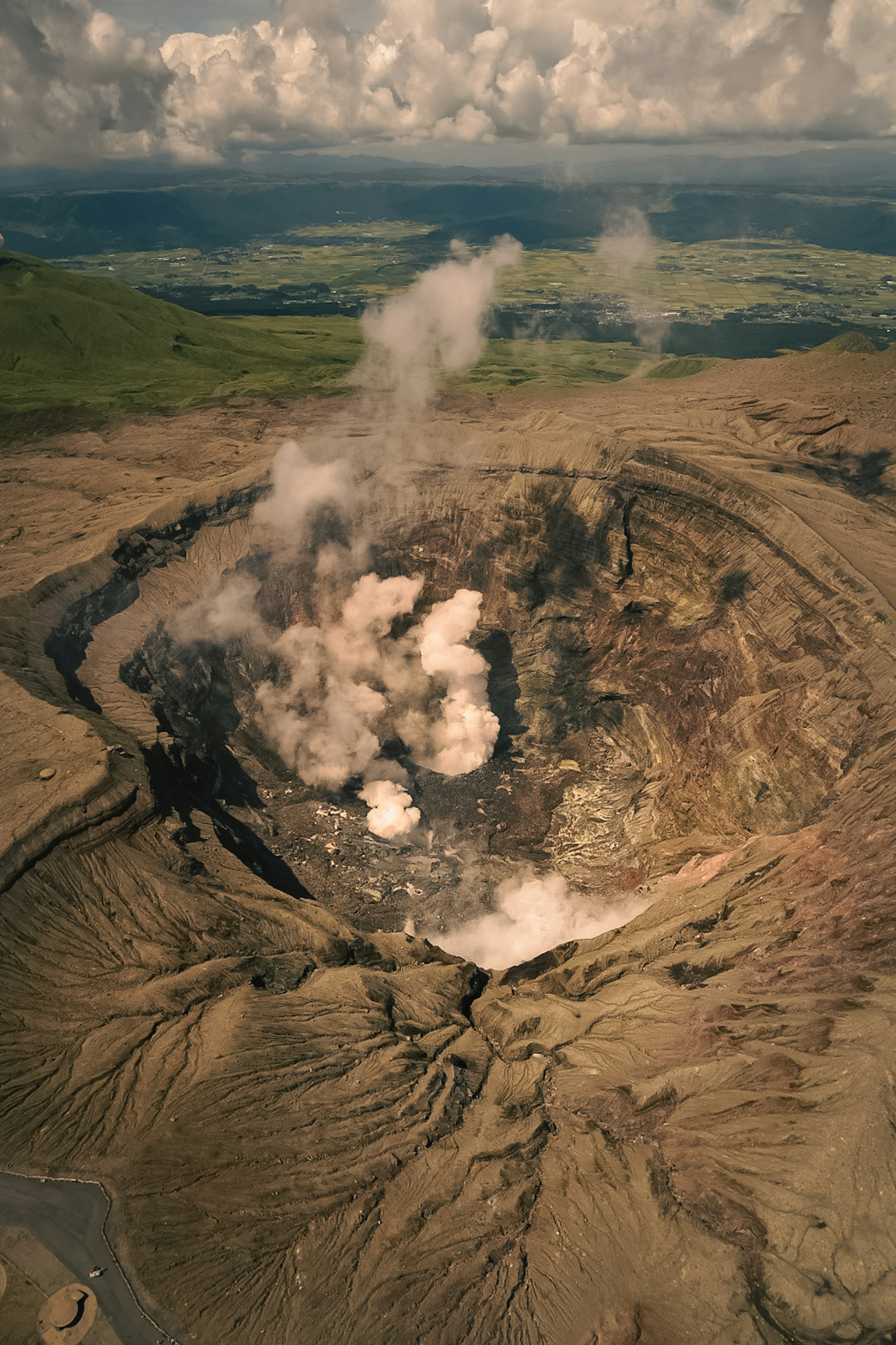 View of a volcanic crater with smoke and eruptions