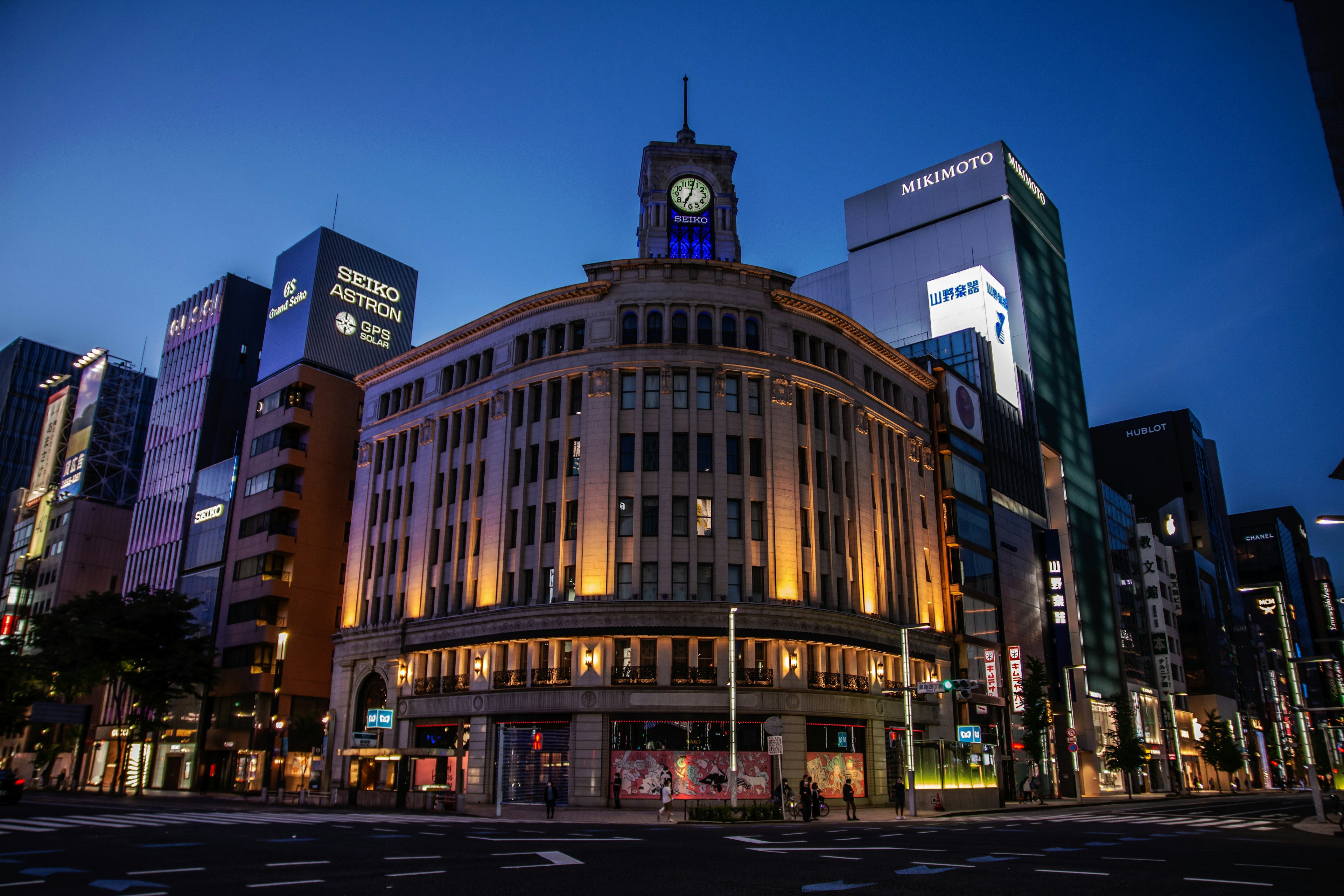 Nachtansicht der Straßen von Ginza mit einem beleuchteten Gebäude und Uhrturm