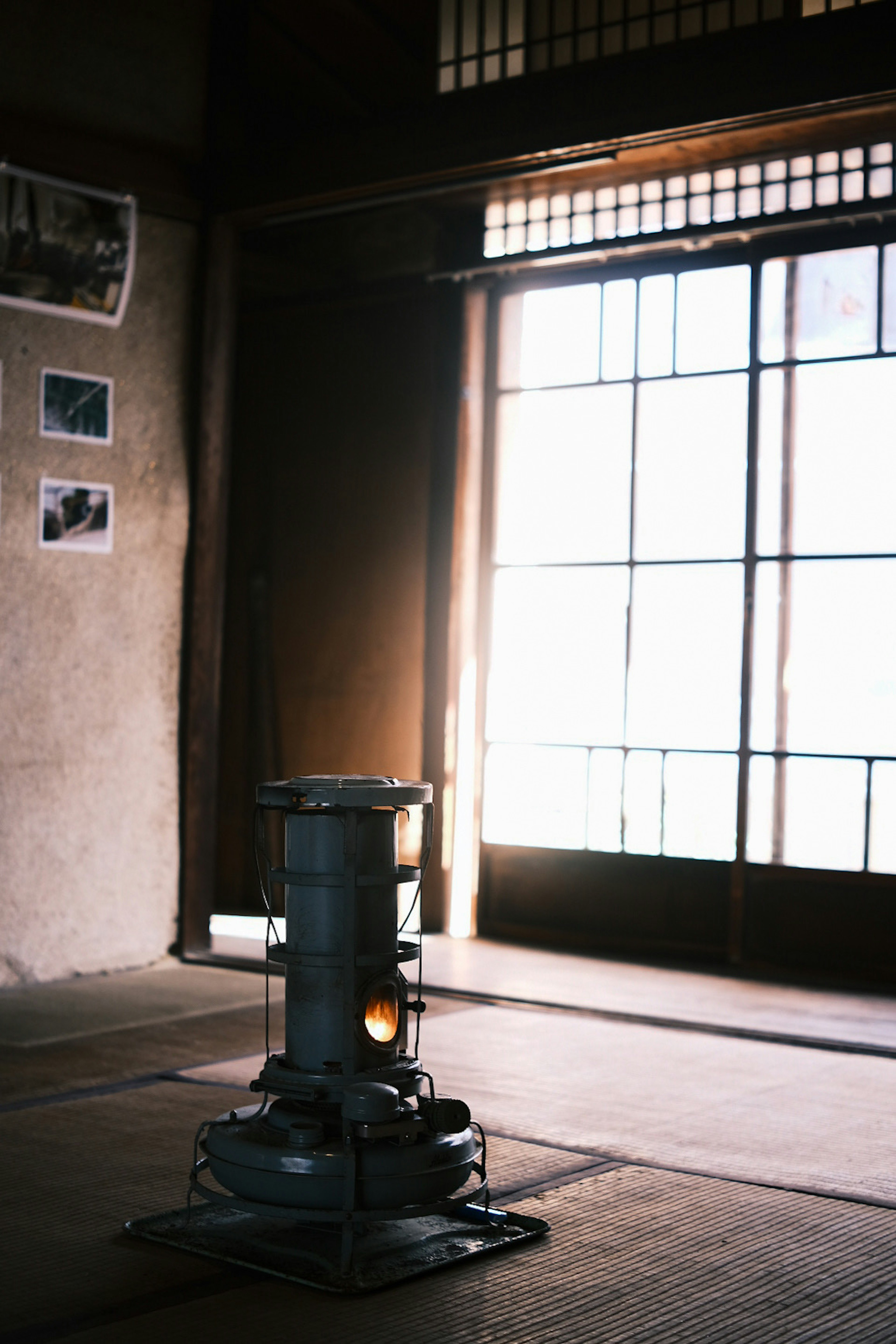 Interior of a traditional Japanese room featuring a stove and large windows