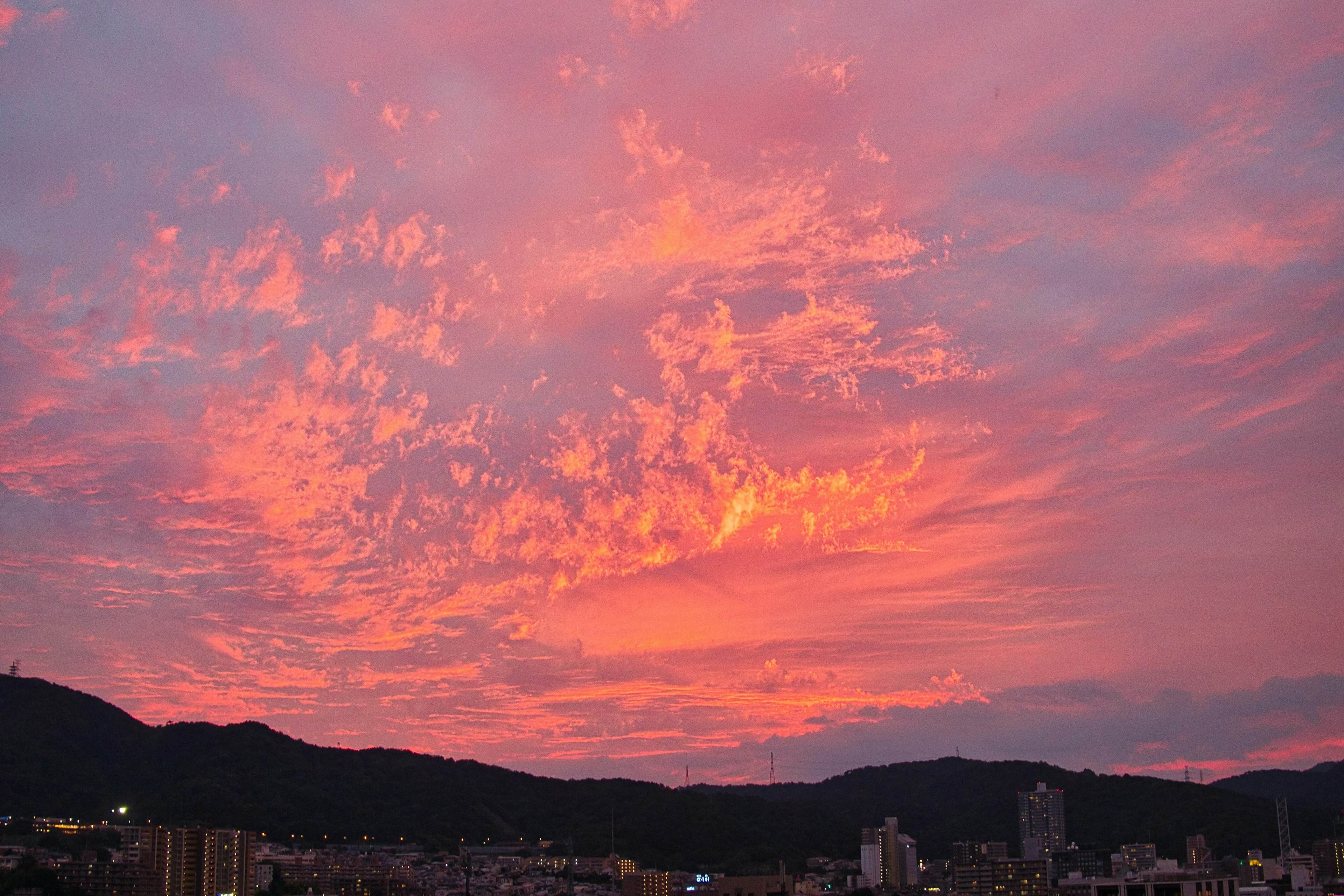 Ciel de coucher de soleil vibrant avec des nuages colorés et des silhouettes de montagnes