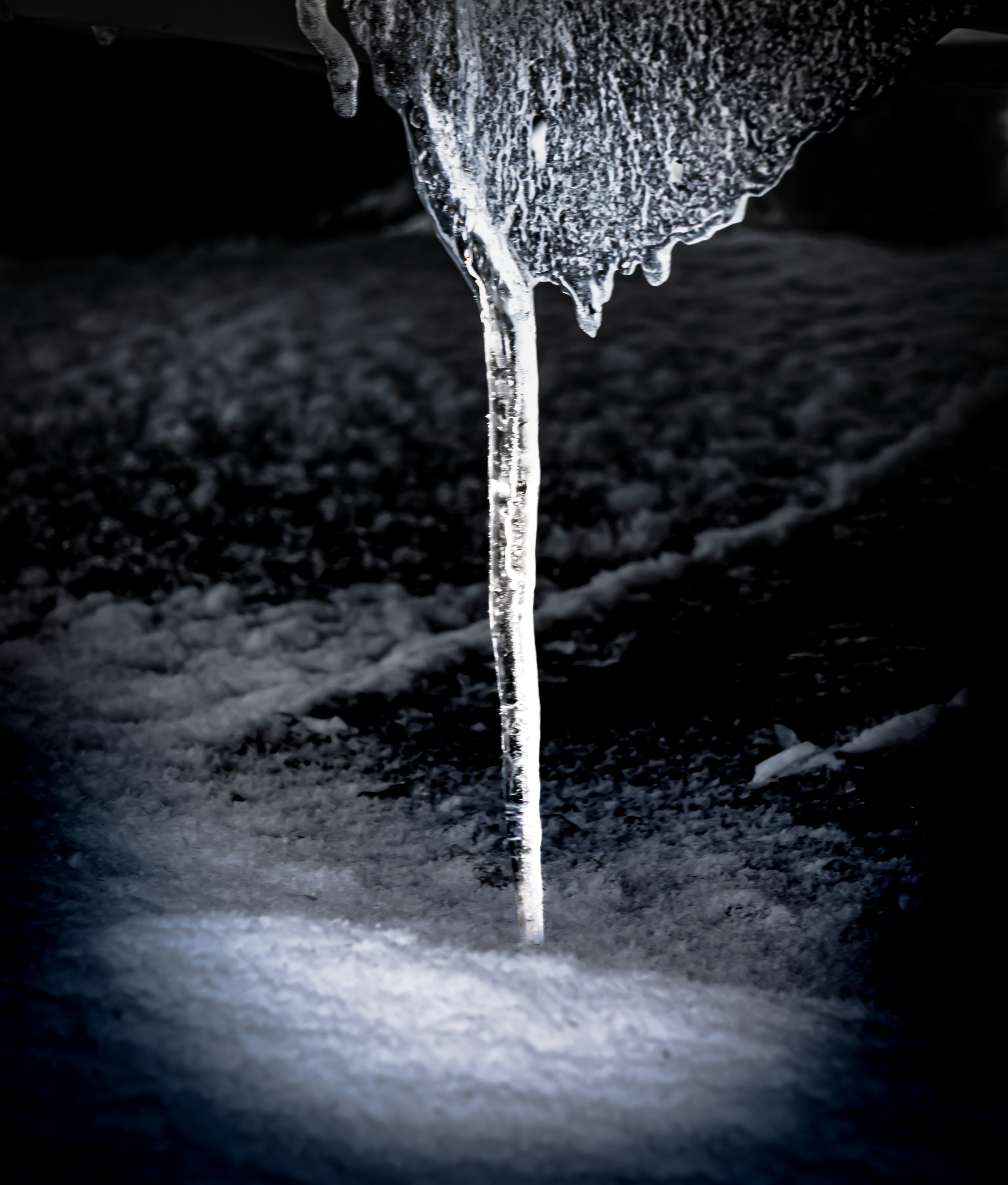 Gota de hielo goteando de un fondo oscuro