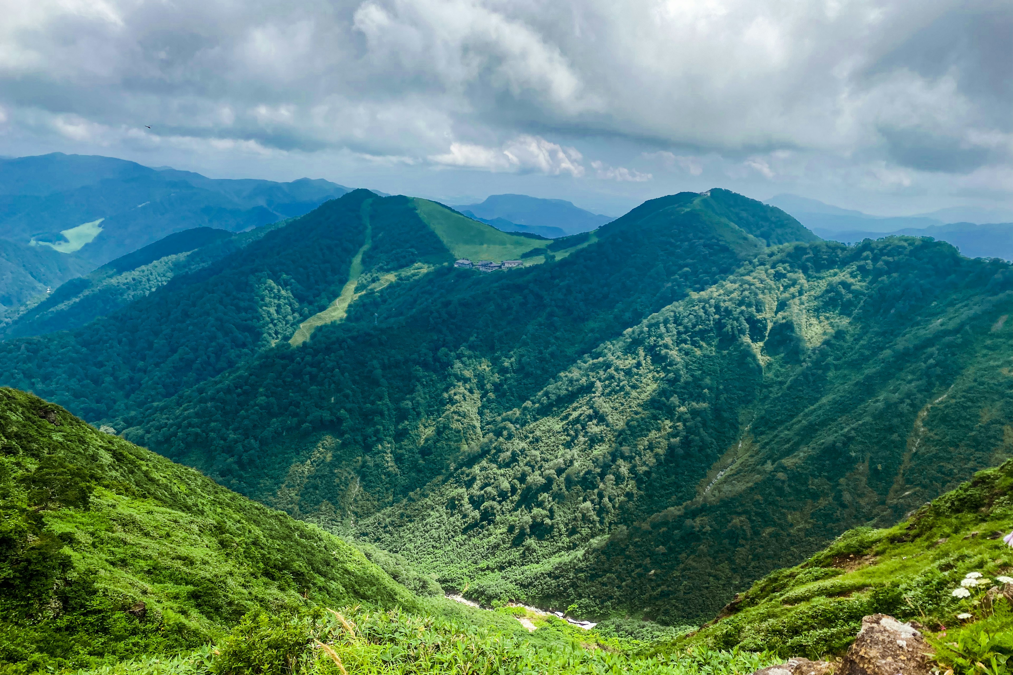 緑豊かな山脈と雲のある空の風景