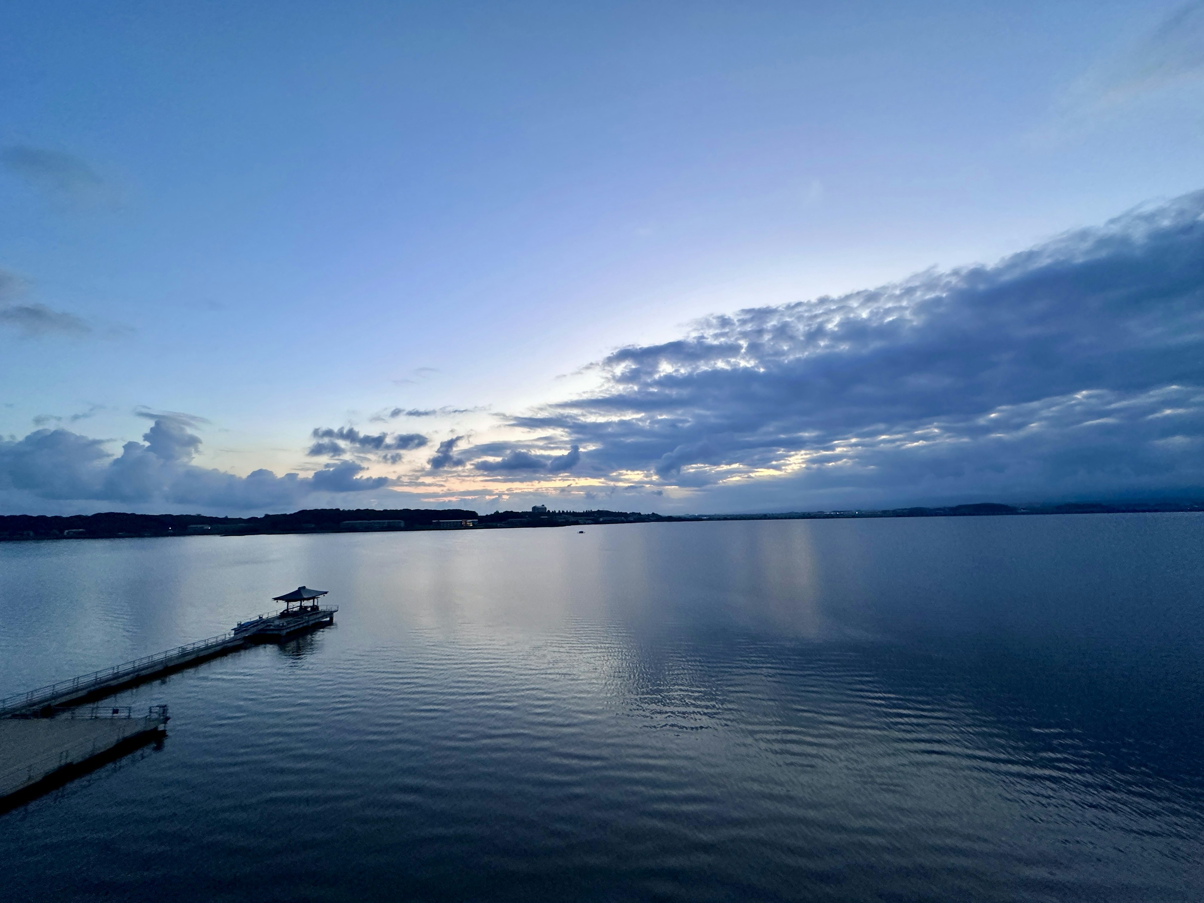 Ruhiger See, der den blauen Himmel und Wolken spiegelt