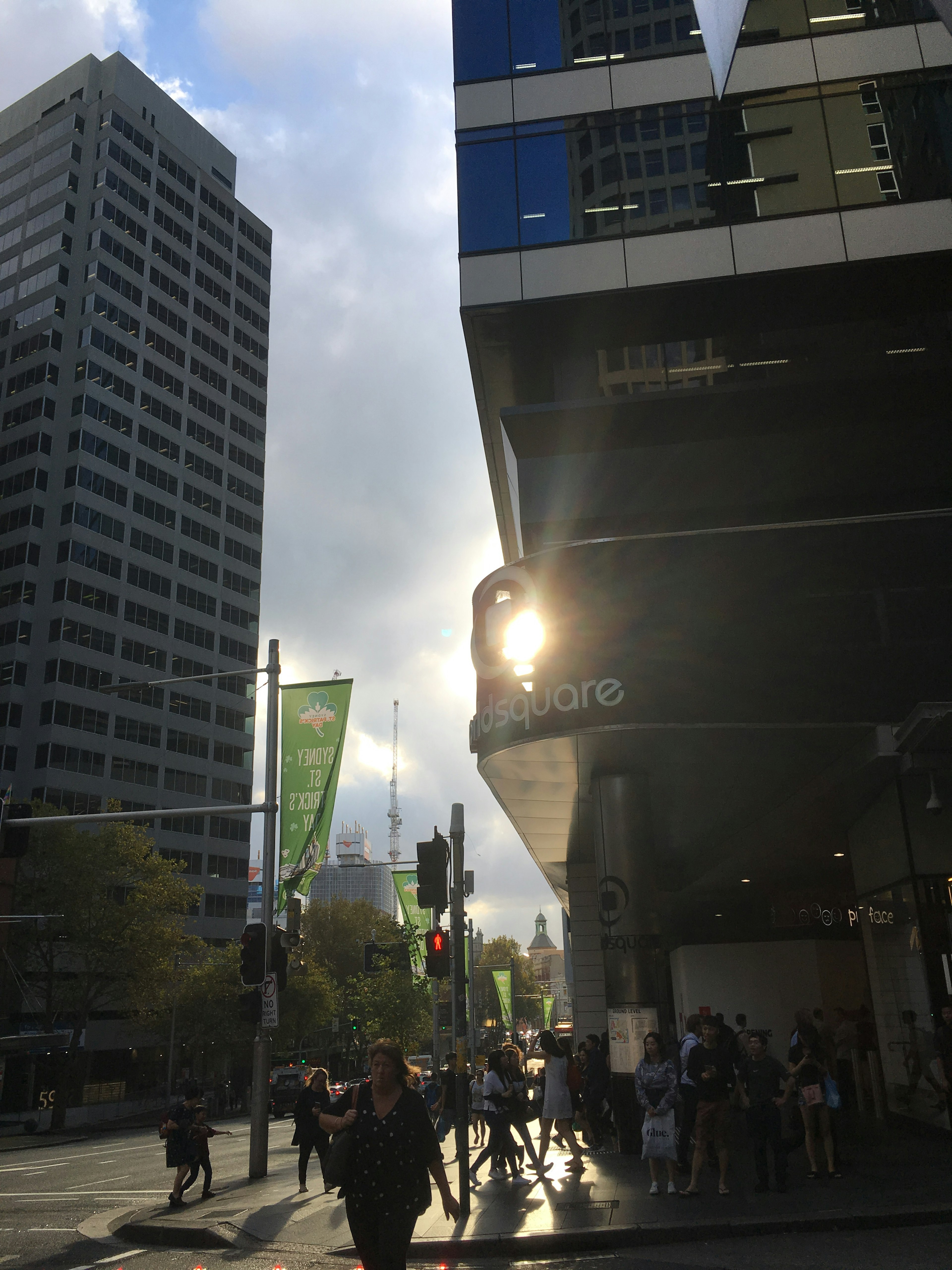 Lumière du soleil se reflétant sur un coin de bâtiment avec des piétons