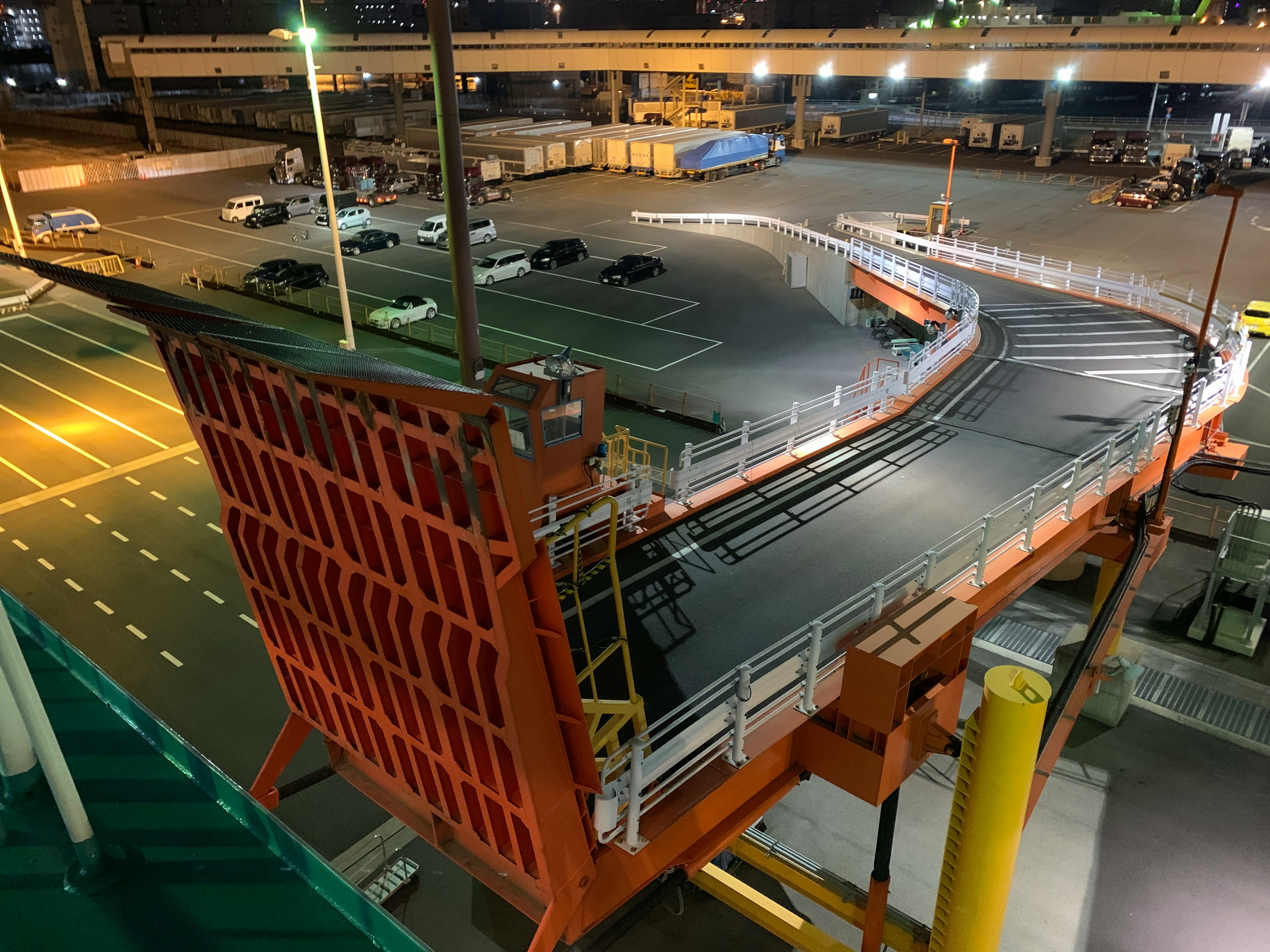 Orange ramp in a parking lot at night with surrounding structures