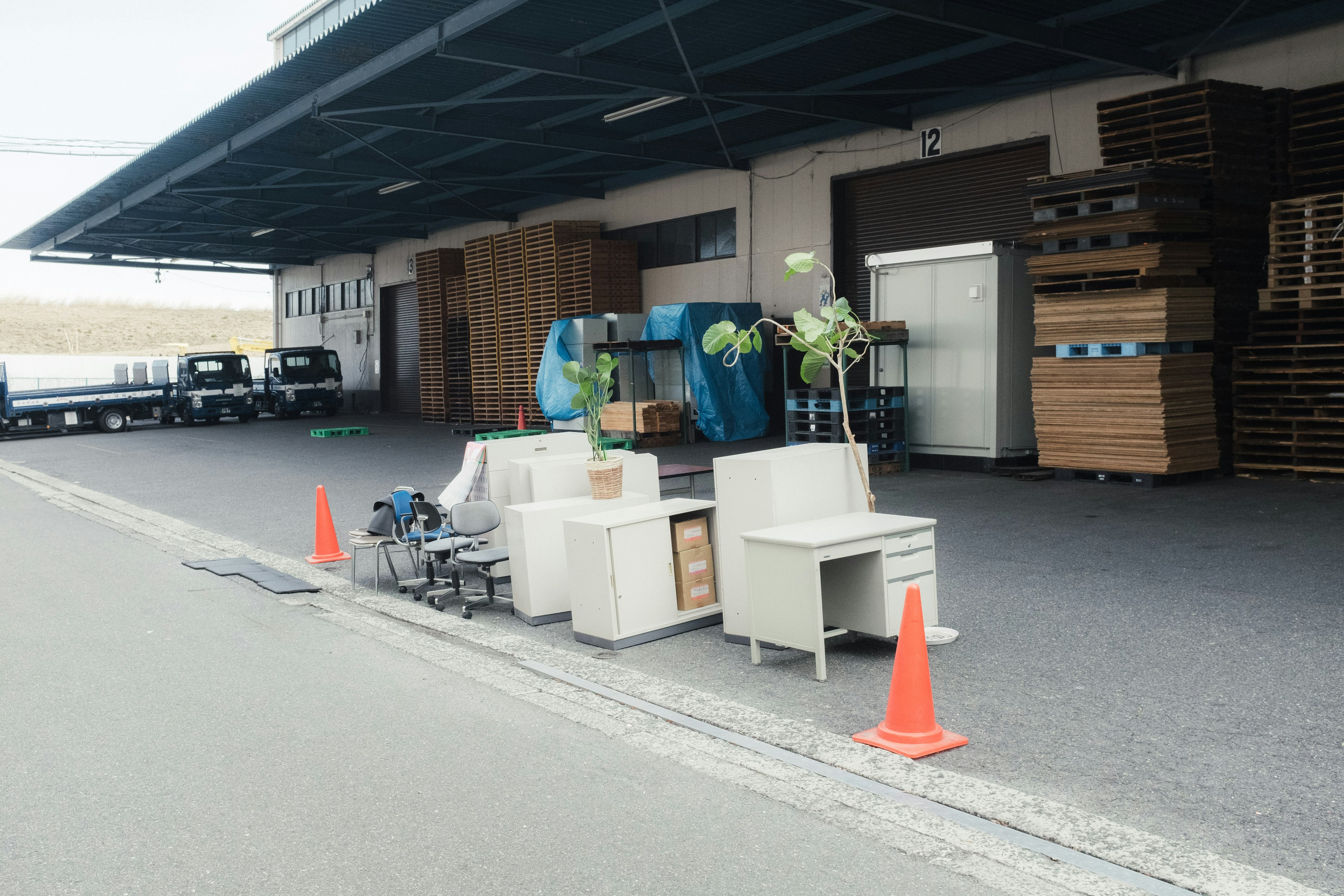 Furniture and plants placed outside a warehouse with traffic cones