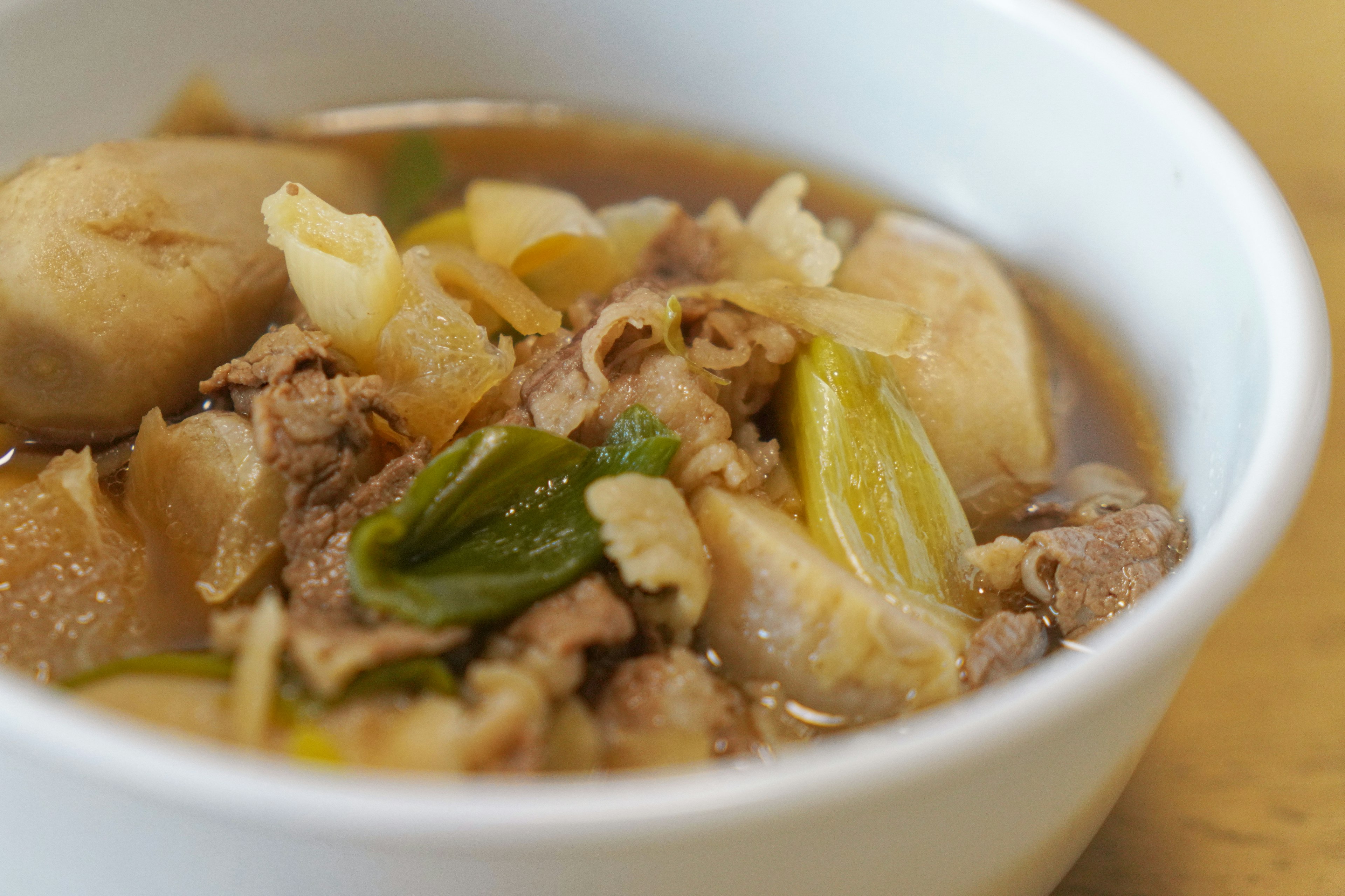 白いボウルに盛られた肉と野菜の煮込み料理