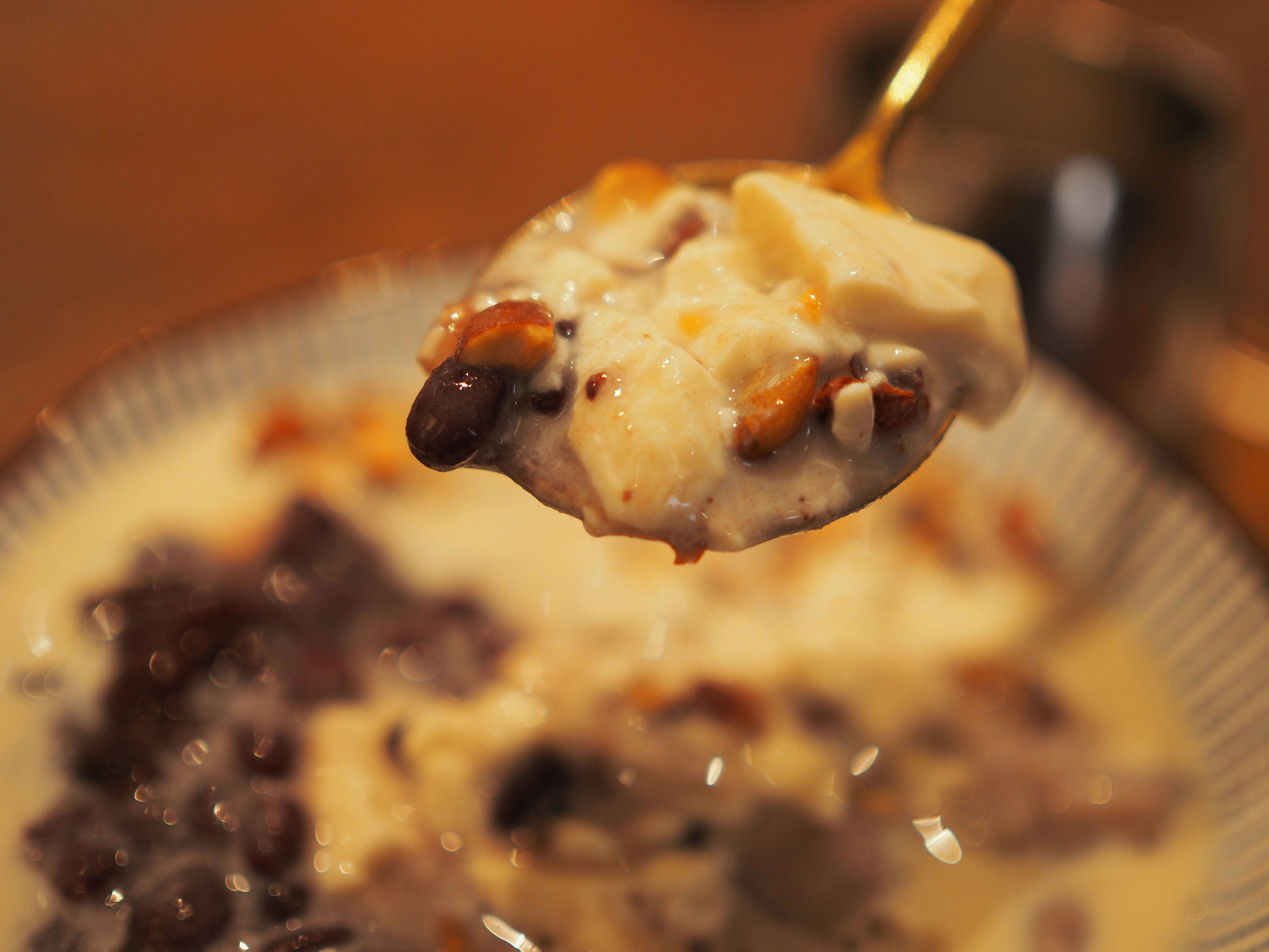 Dessert mit süßen Bohnen und cremigem Belag auf einem Löffel