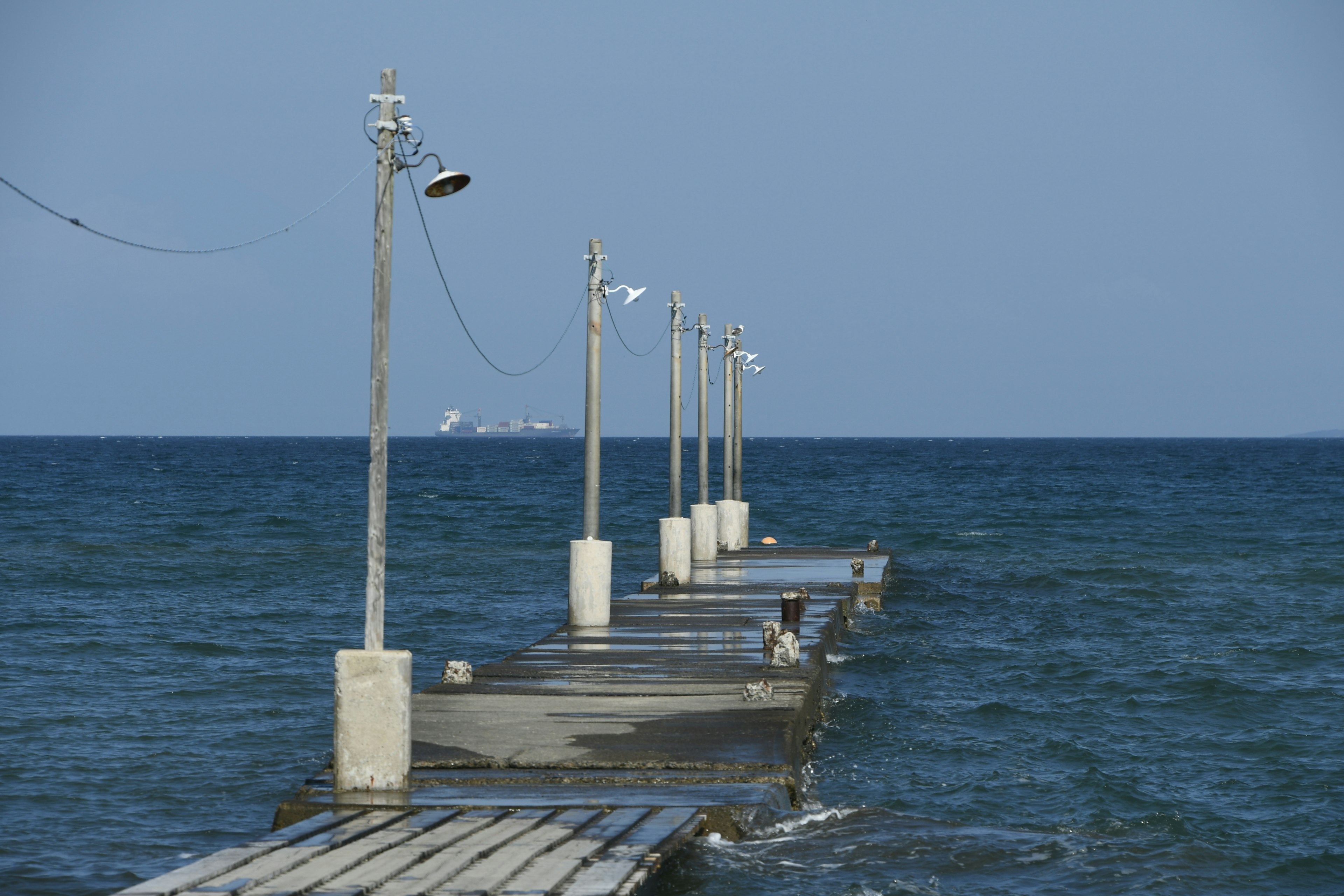 Muelle de madera que se extiende en el mar azul con luces