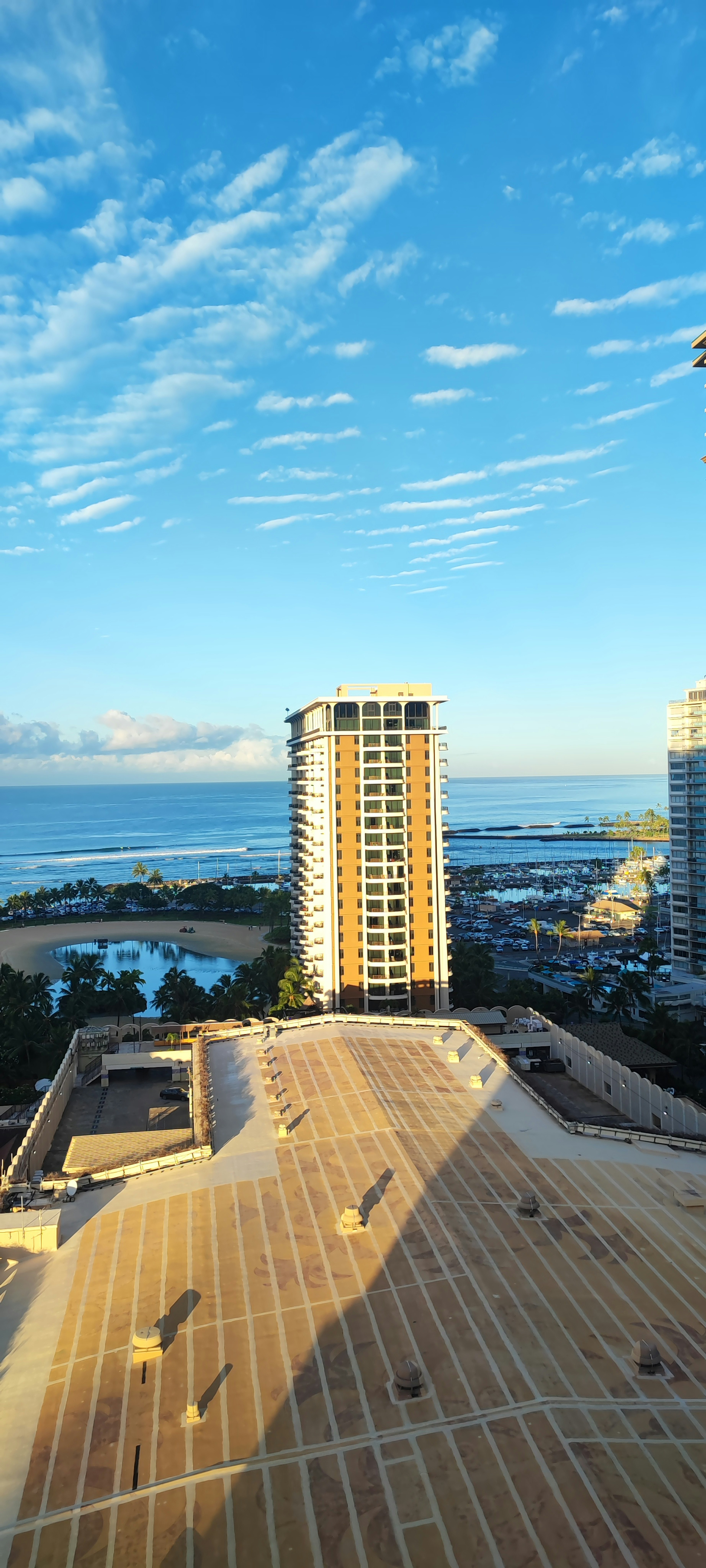 Skyline view featuring a tall building and ocean under a blue sky