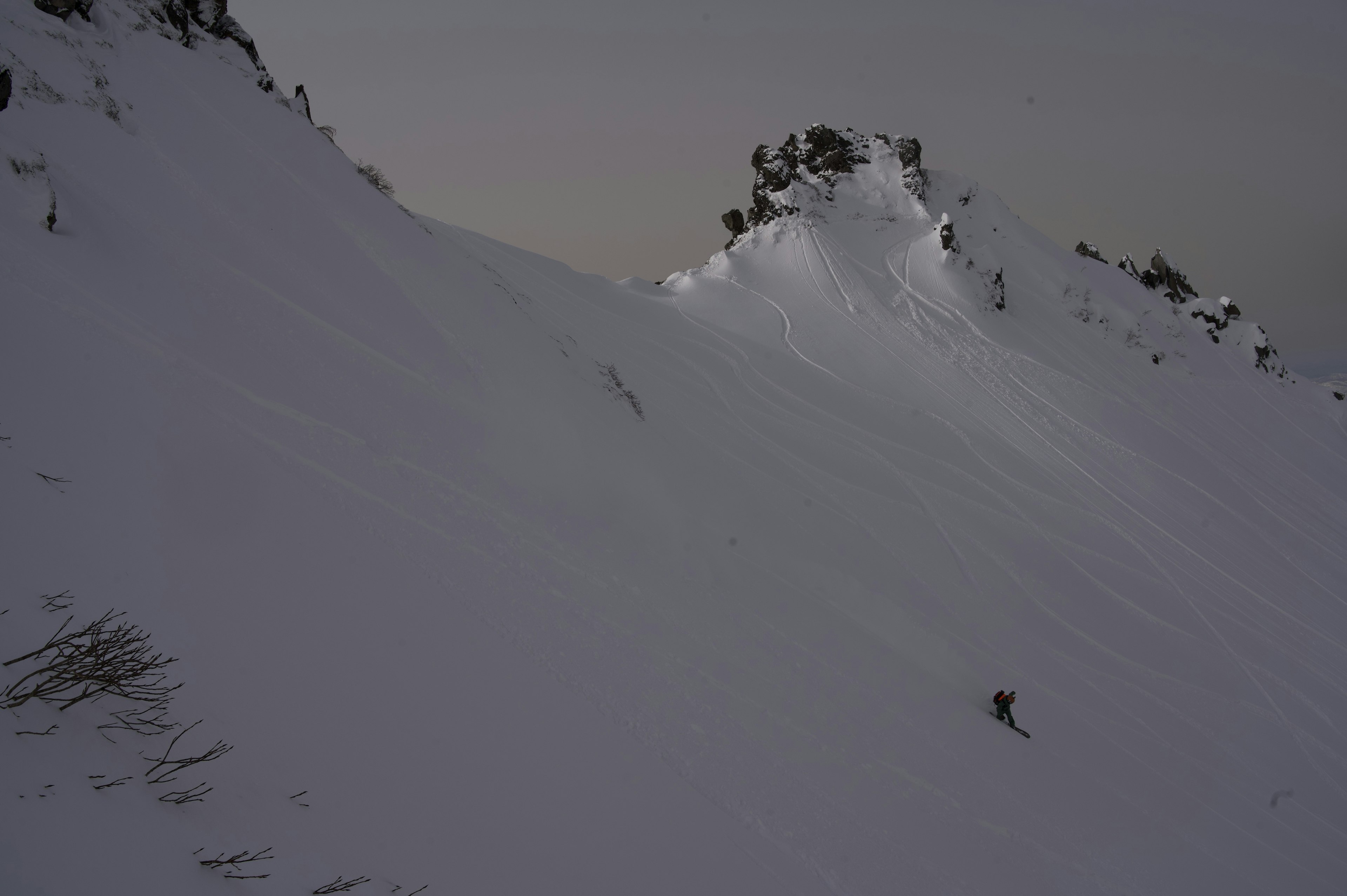 Punggungan gunung yang tertutup salju dengan seorang pemain ski