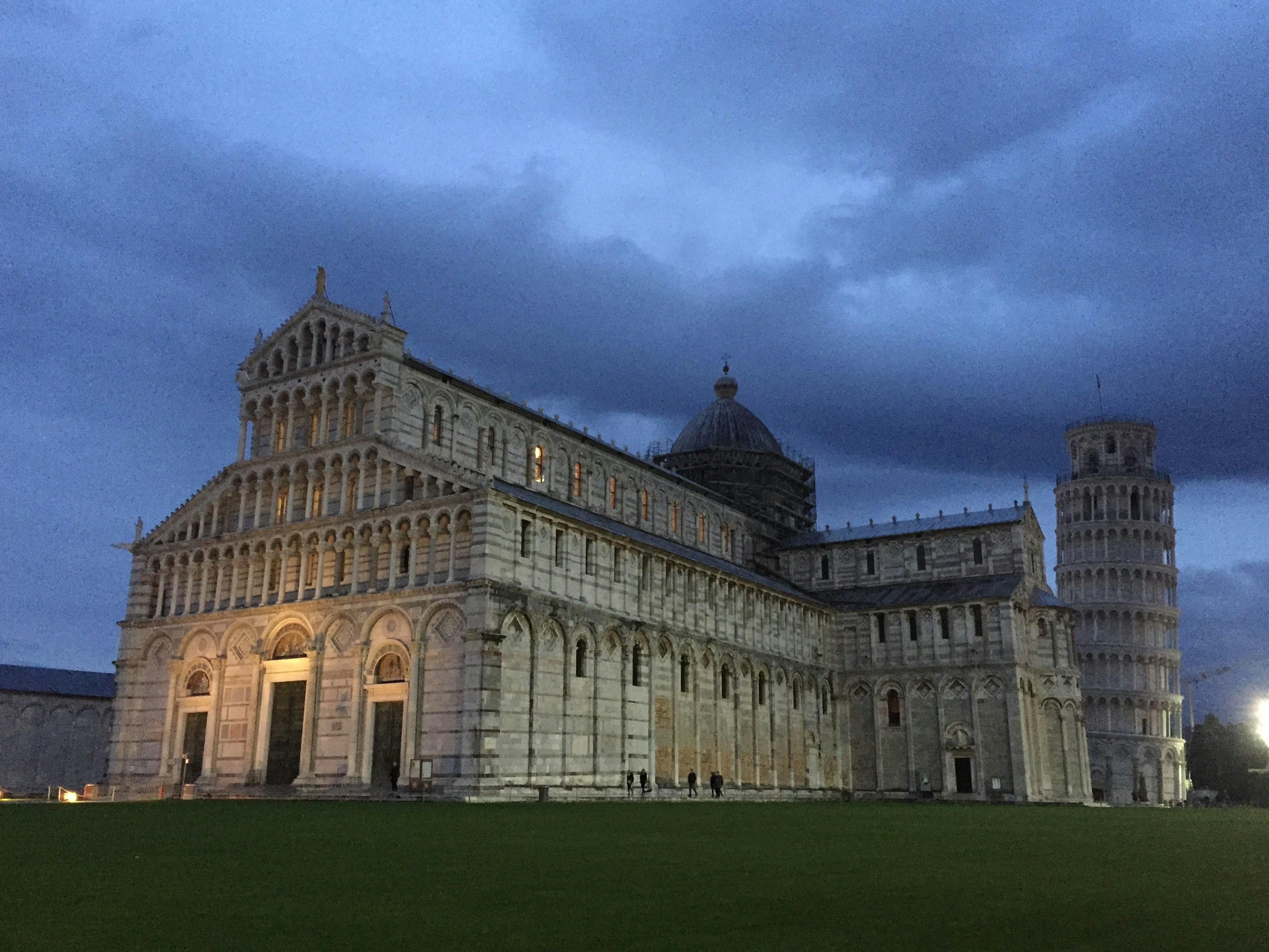 Der Dom von Pisa und der Schiefe Turm von Pisa beleuchtet unter einem Dämmerungshimmel