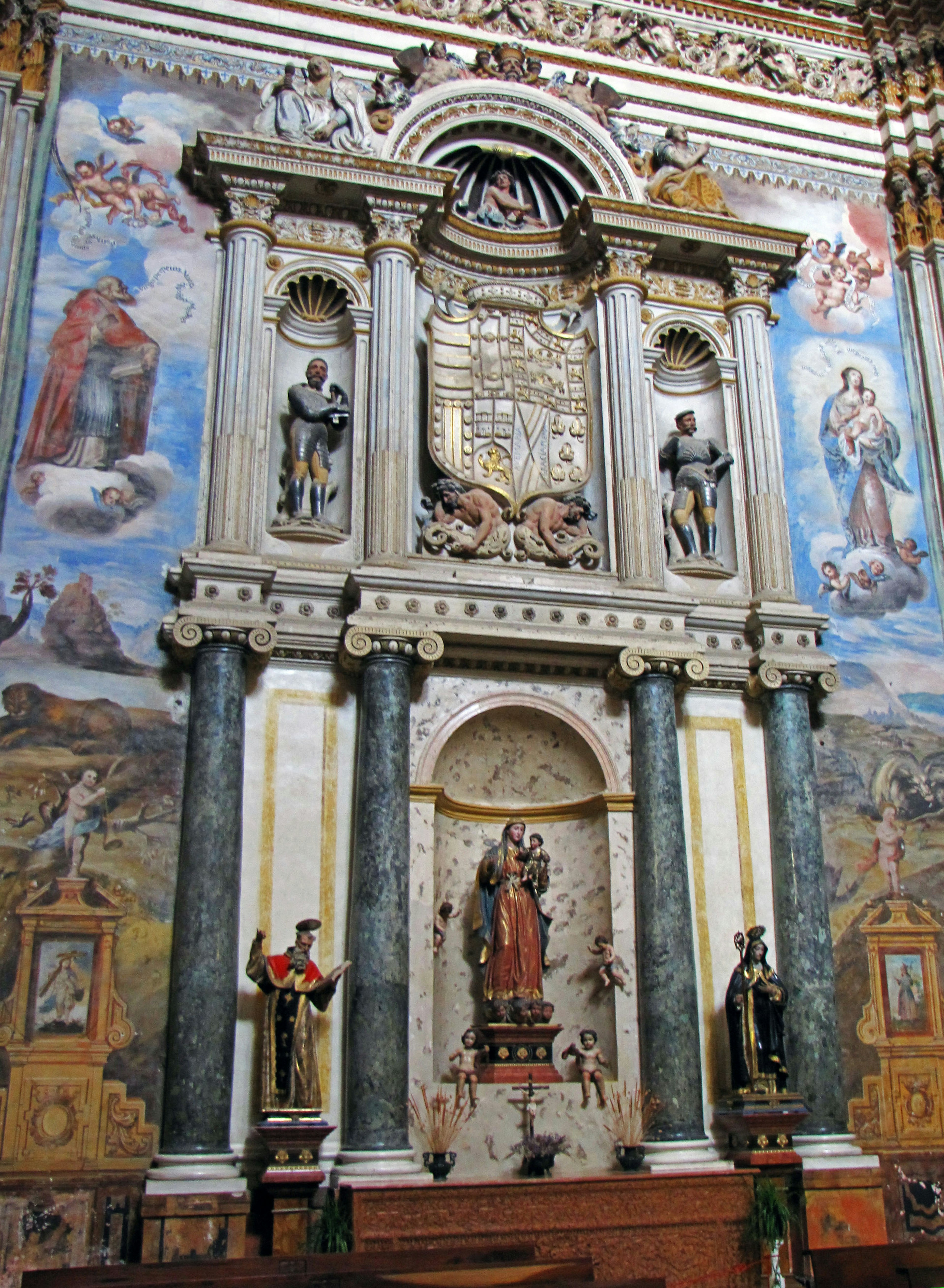 Ornately decorated church altar featuring sculptures and paintings in the background