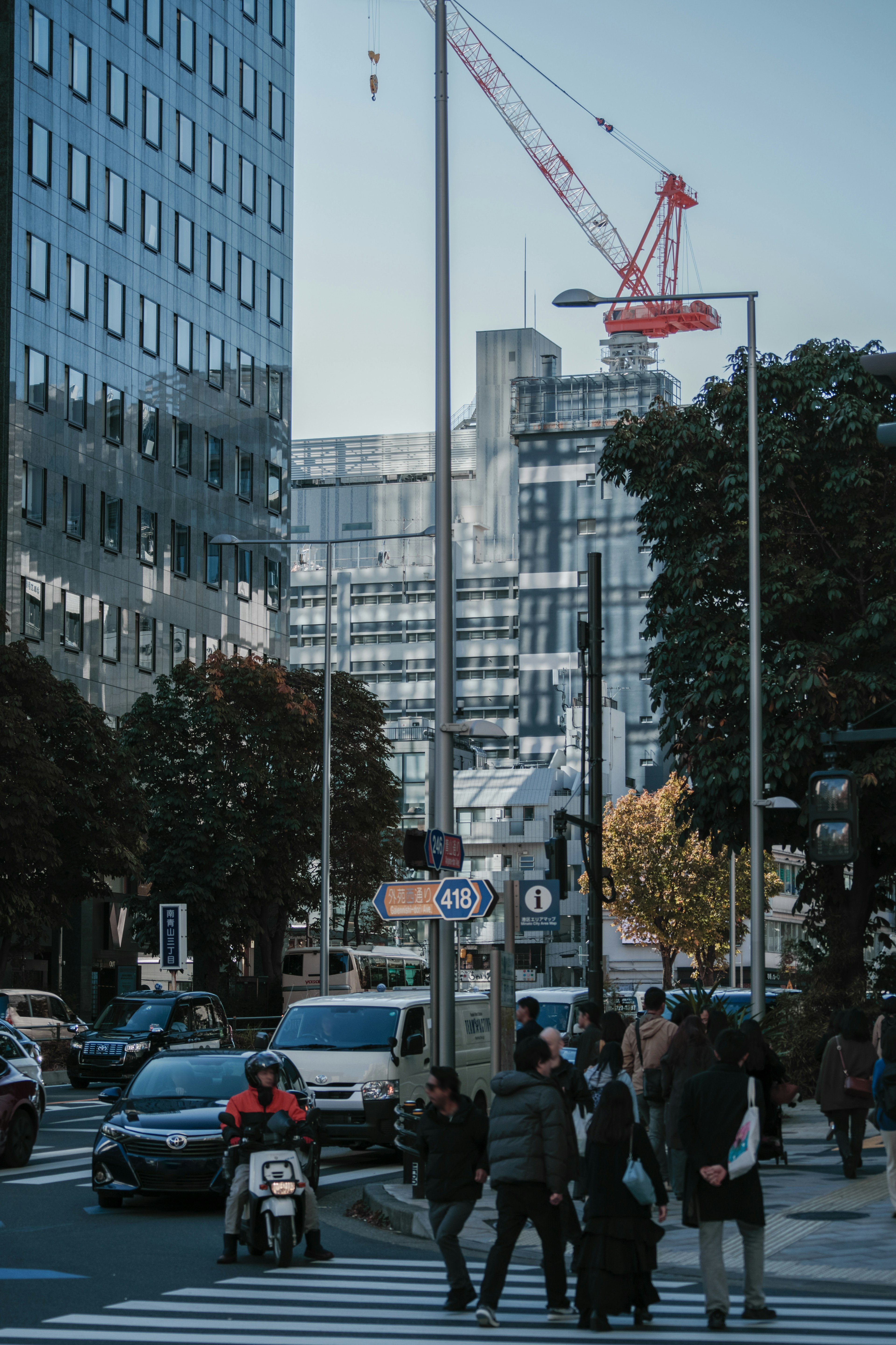 城市景观中人们穿越街道，高楼大厦和起重机