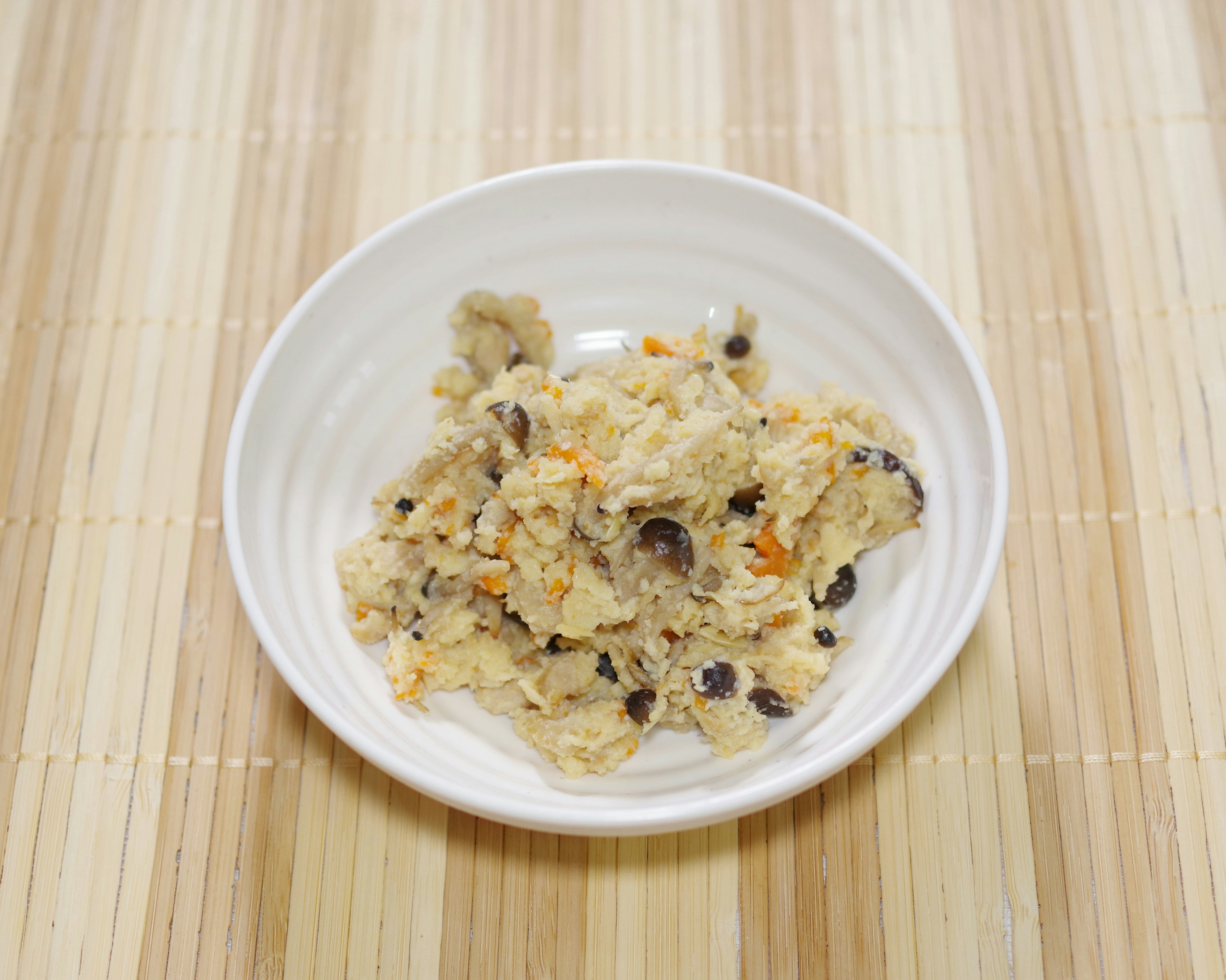 Plat avec un mélange contenant des haricots noirs et des morceaux d'orange servi dans un bol blanc