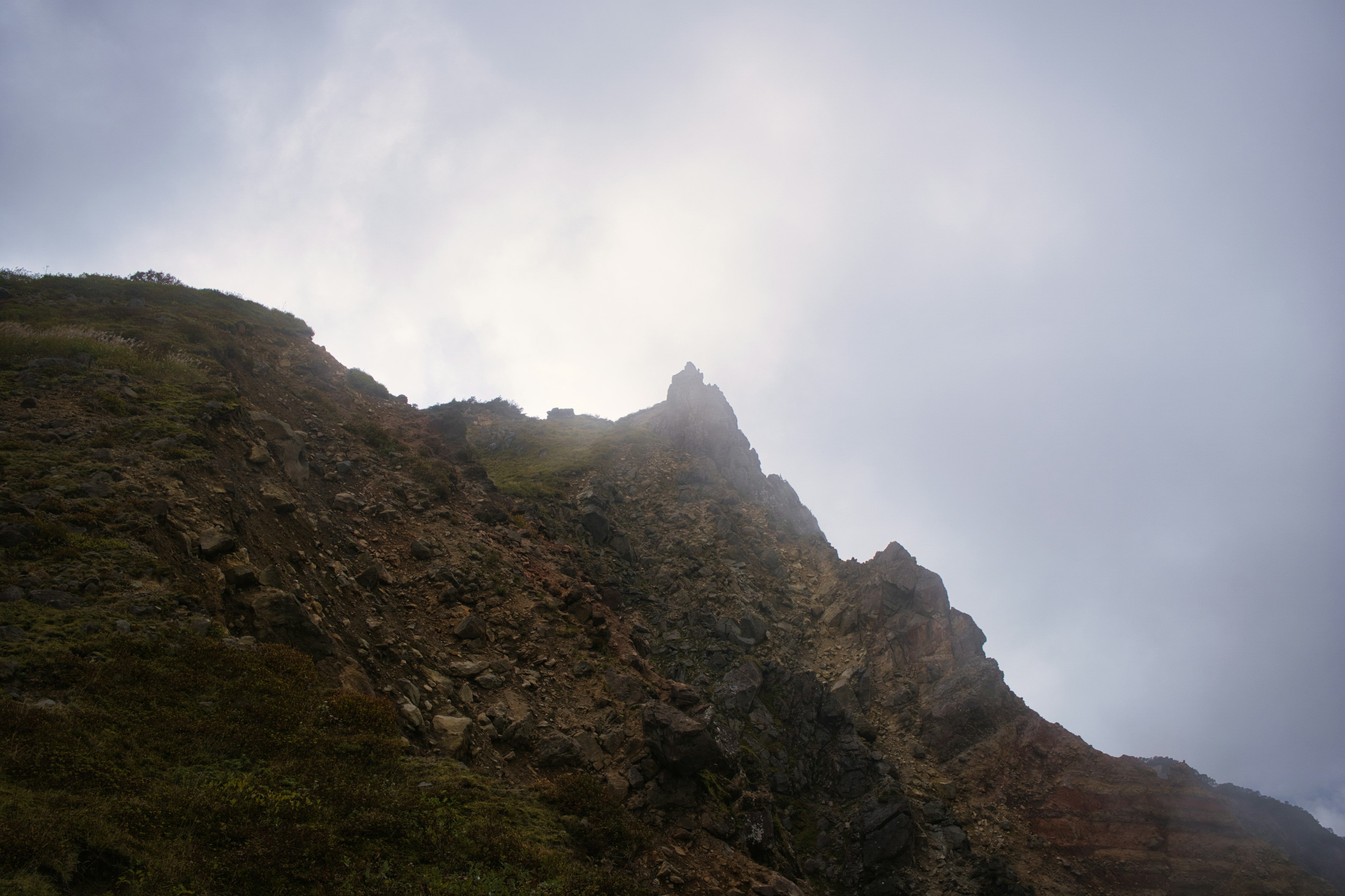 Puncak gunung berbatu yang diselimuti kabut