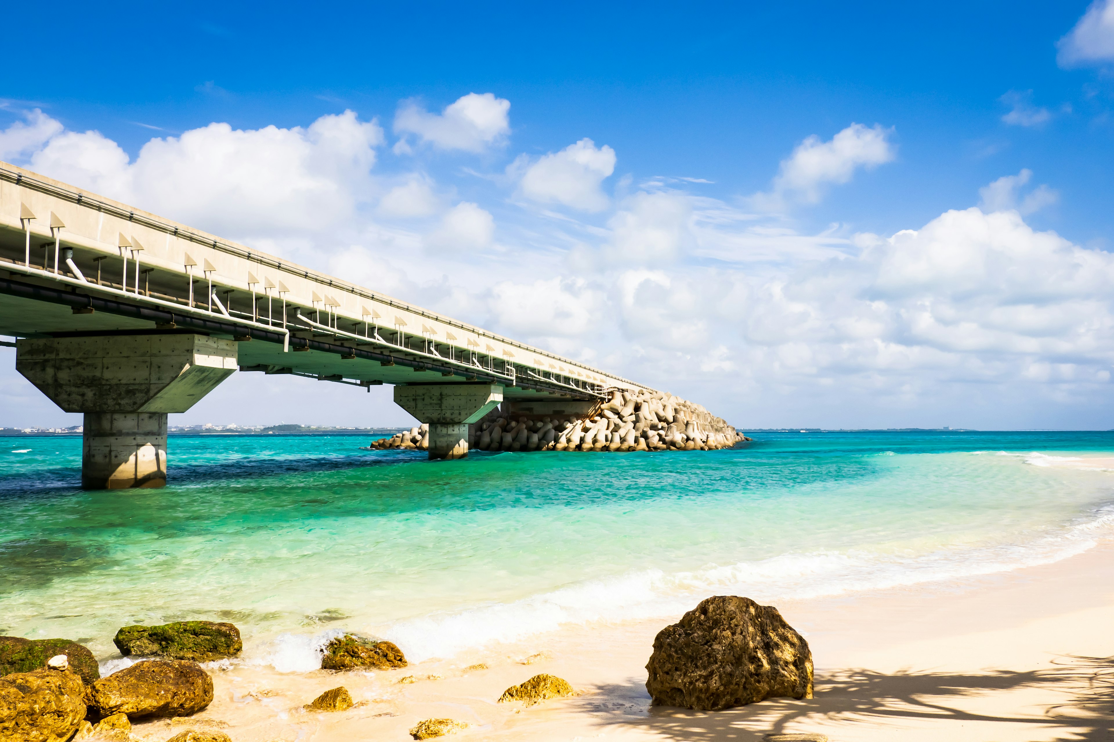 Vista escénica de un puente sobre aguas turquesas y playa de arena