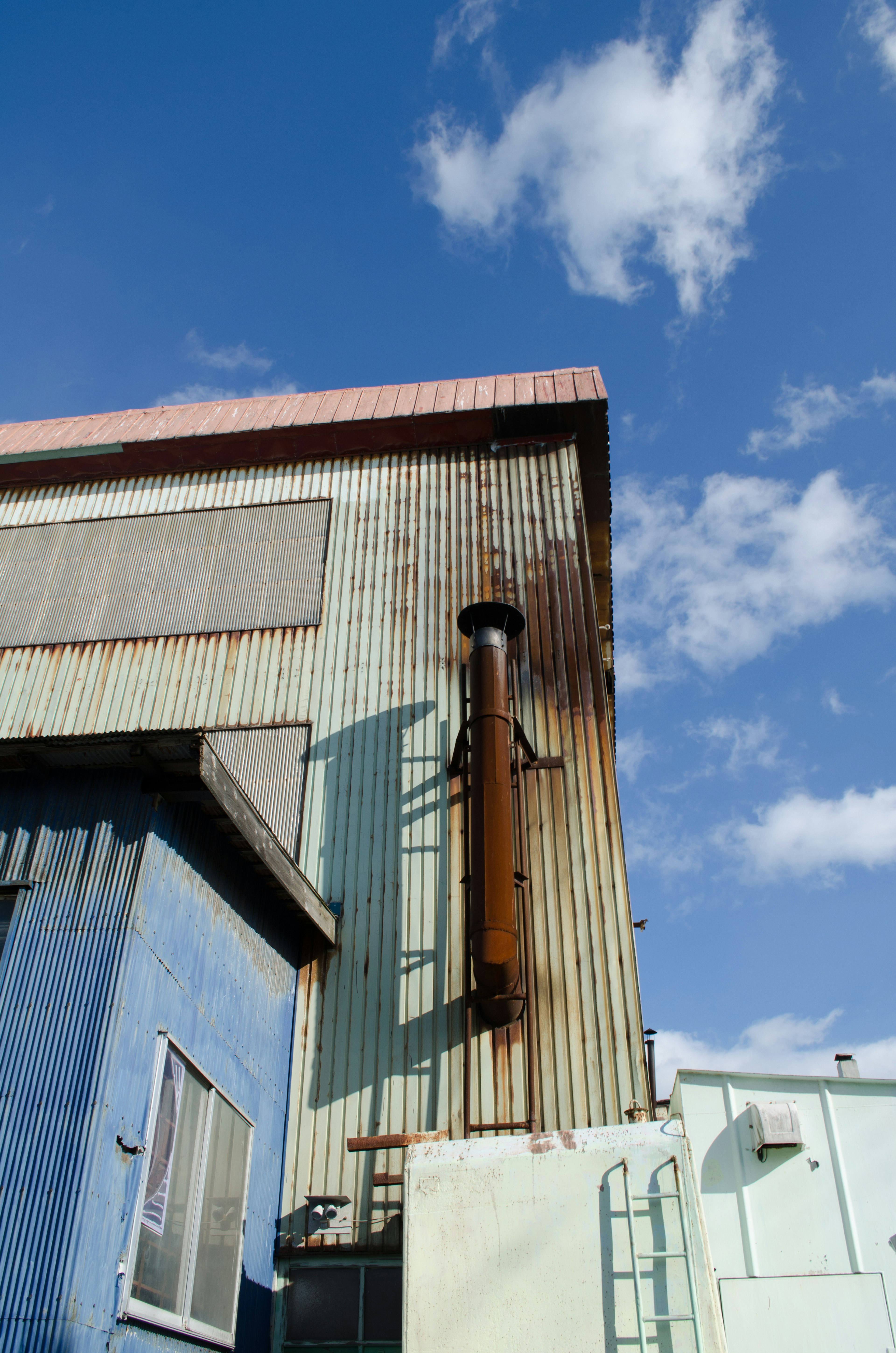 Scène industrielle avec un mur bleu et une structure métallique