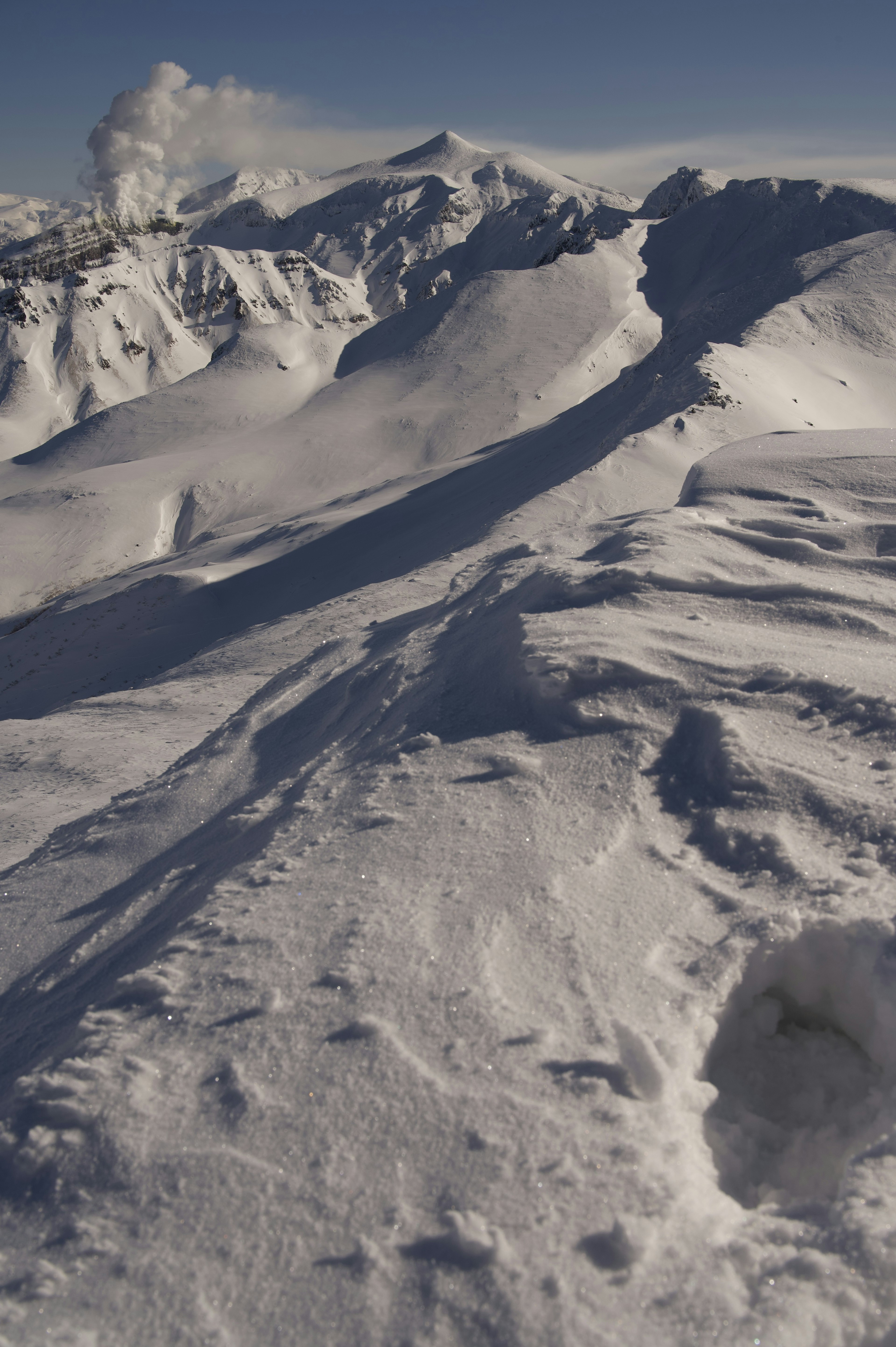 Snow-covered mountain landscape under a clear blue sky