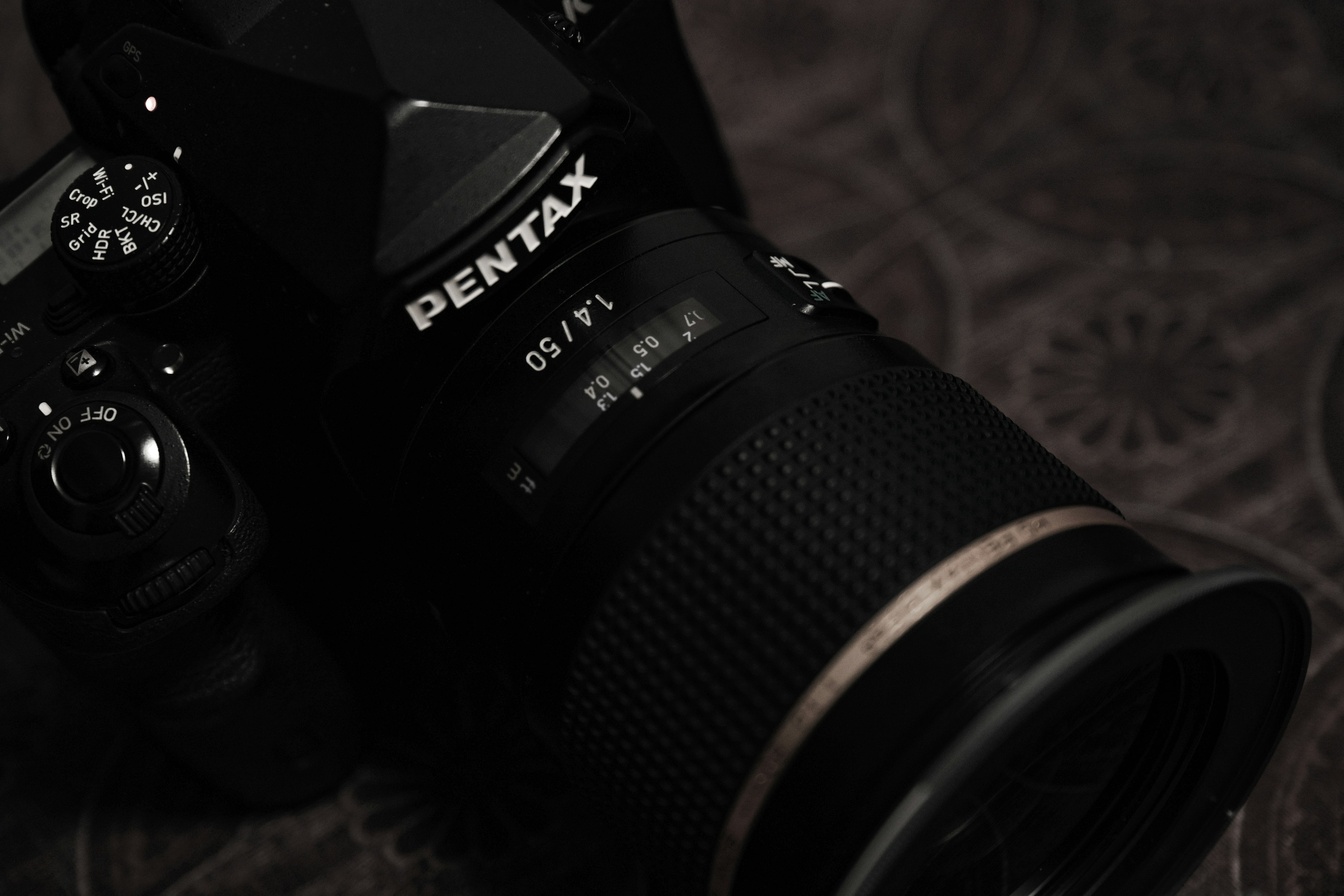 Primo piano di una fotocamera Pentax che mette in evidenza l'obiettivo e i dettagli