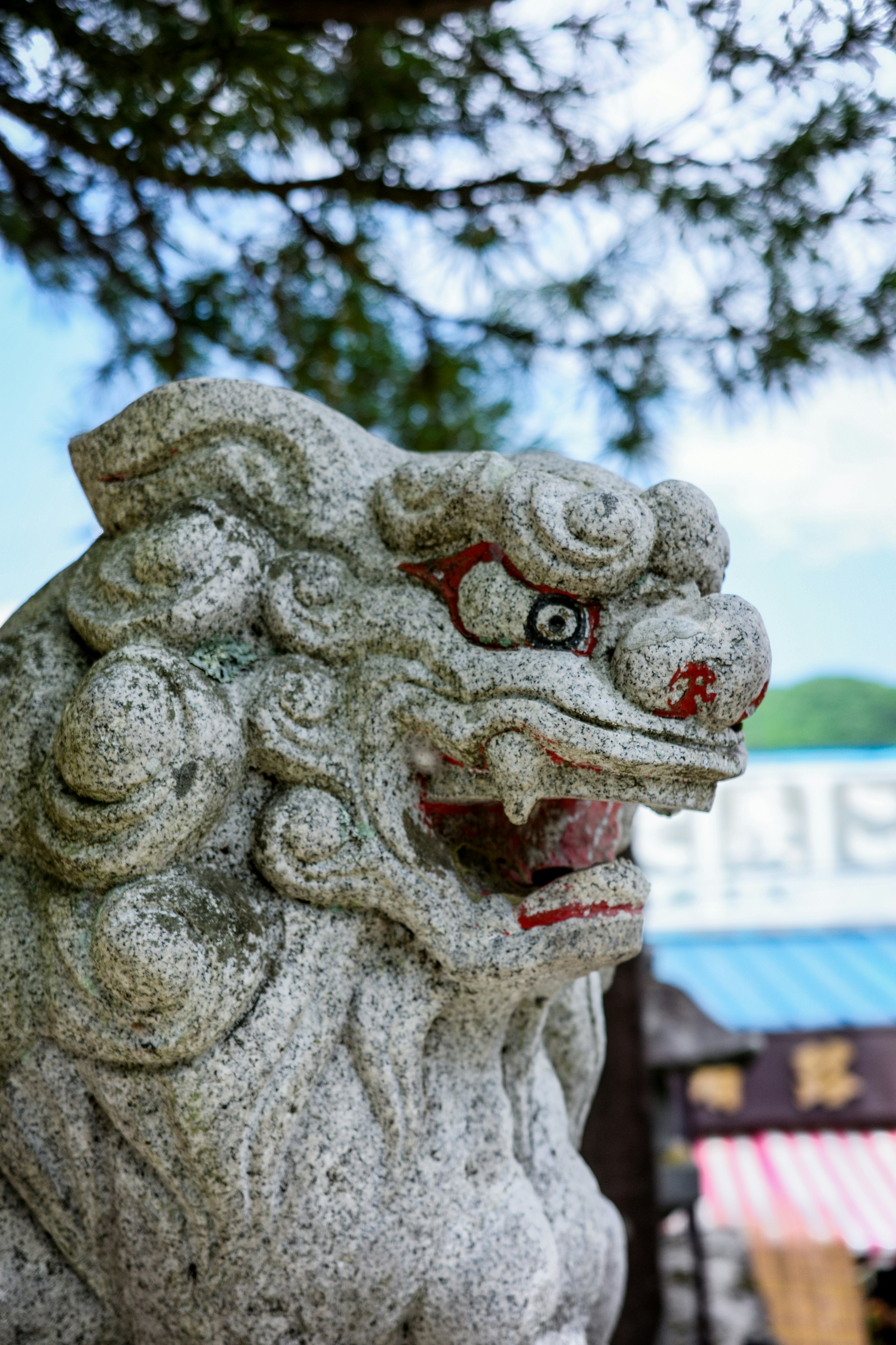 Steinlöwenstatue mit wütendem Ausdruck vor blauem Himmel