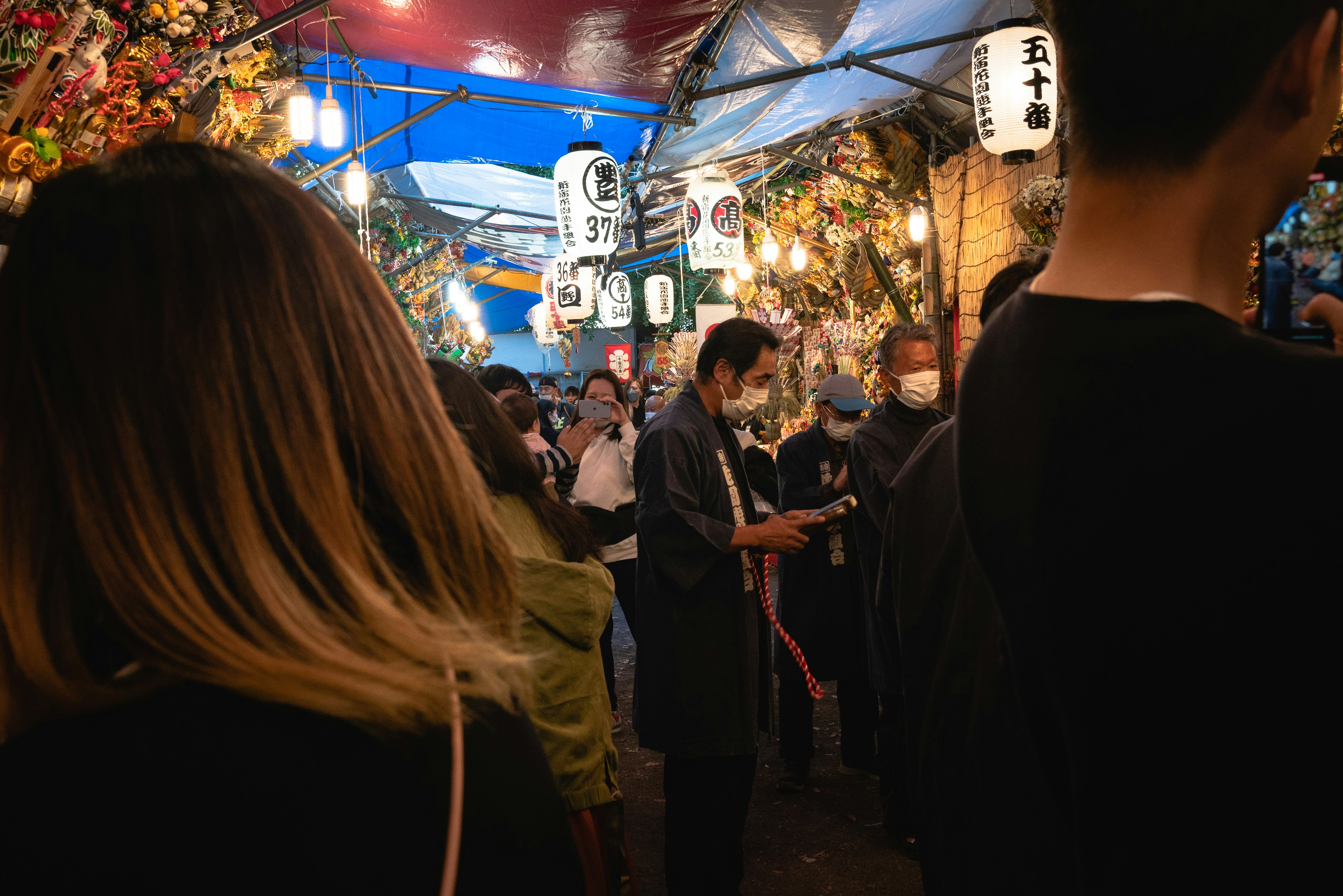 Scena di mercato notturno affollato con bancarelle di cibo persone che si godono l'atmosfera illuminata da lanterne