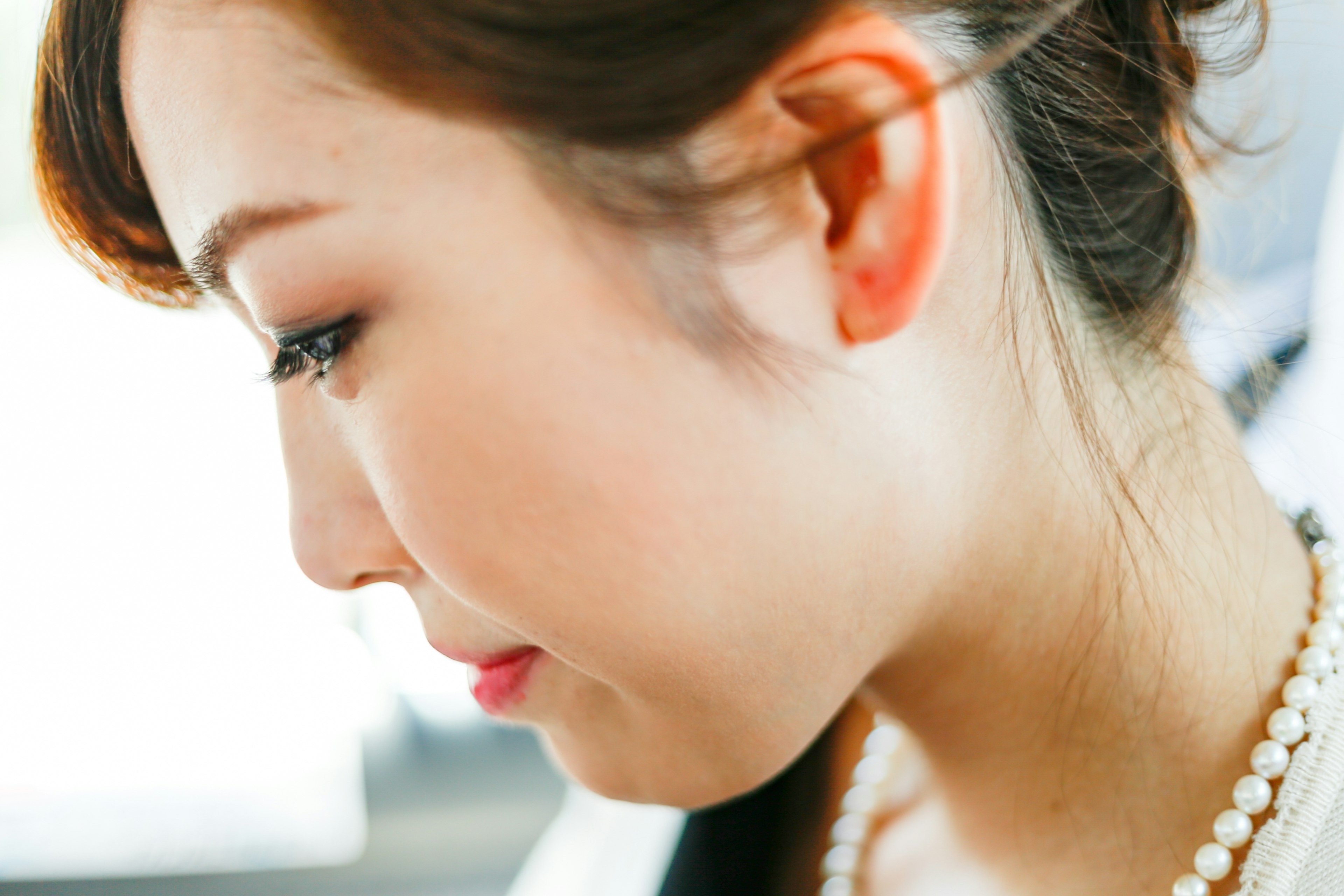 Profil d'une femme avec un collier de perles et un éclairage doux