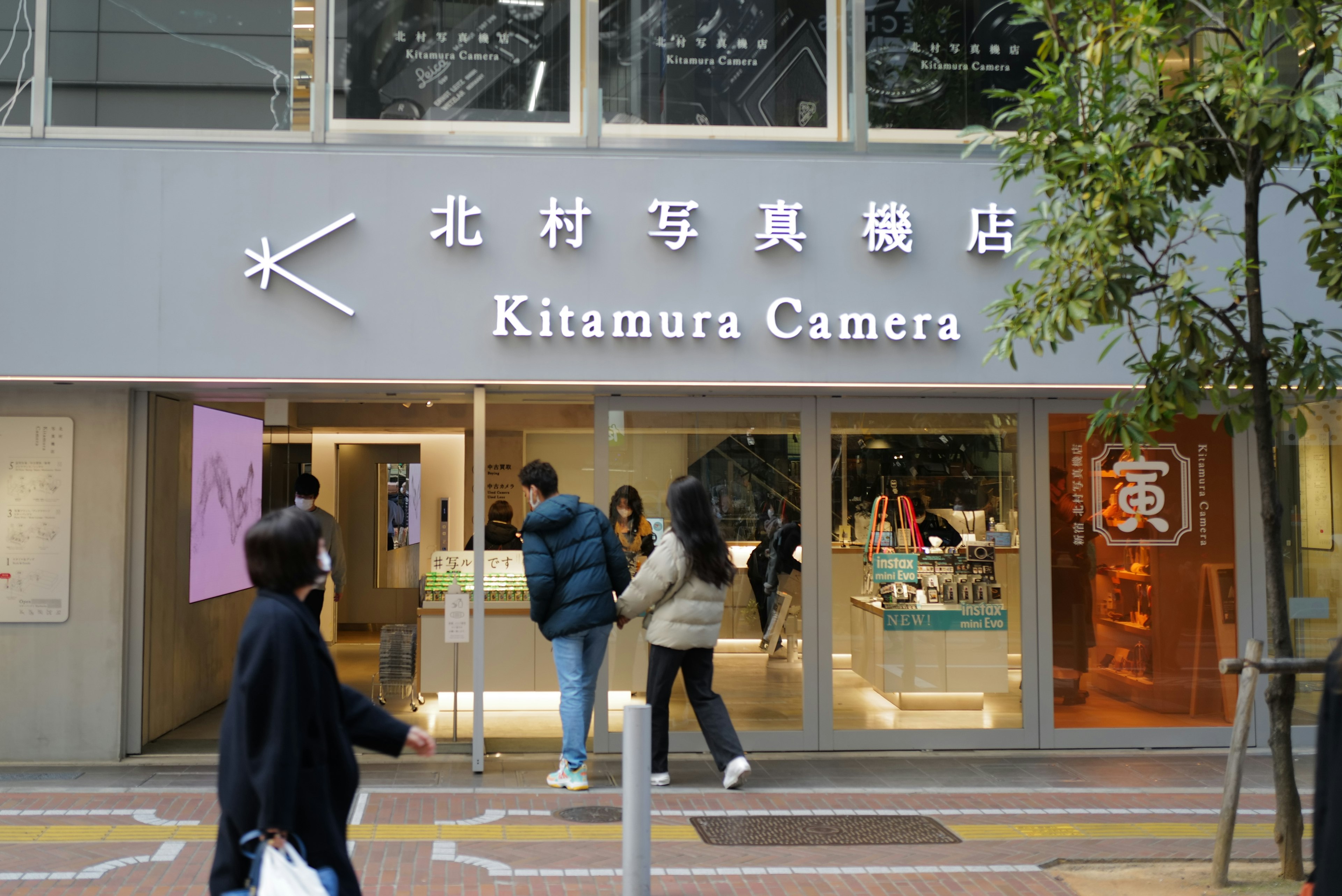 Exterior de la tienda Kitamura Camera con personas entrando y saliendo