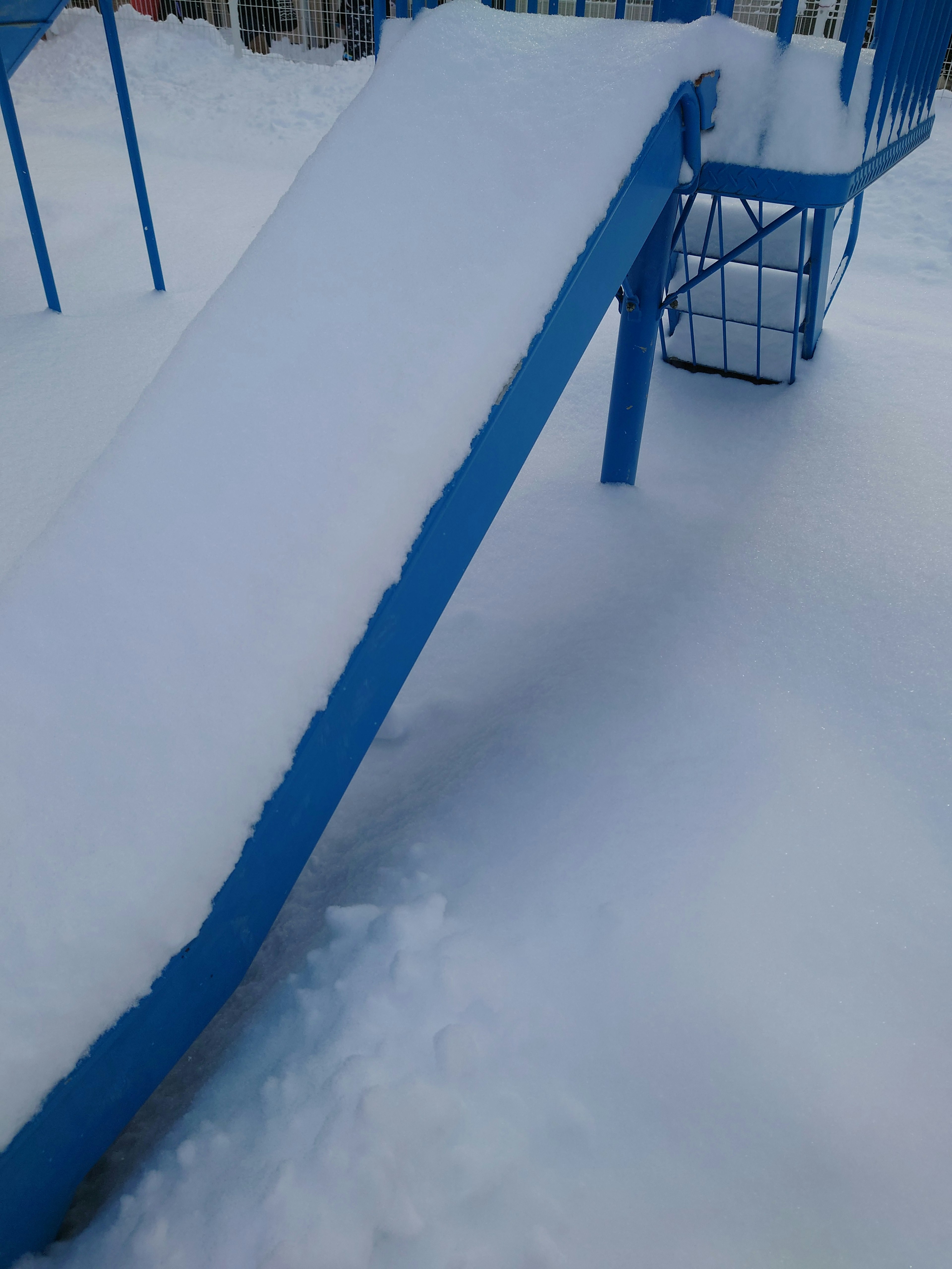 Foto de un tobogán azul cubierto de nieve