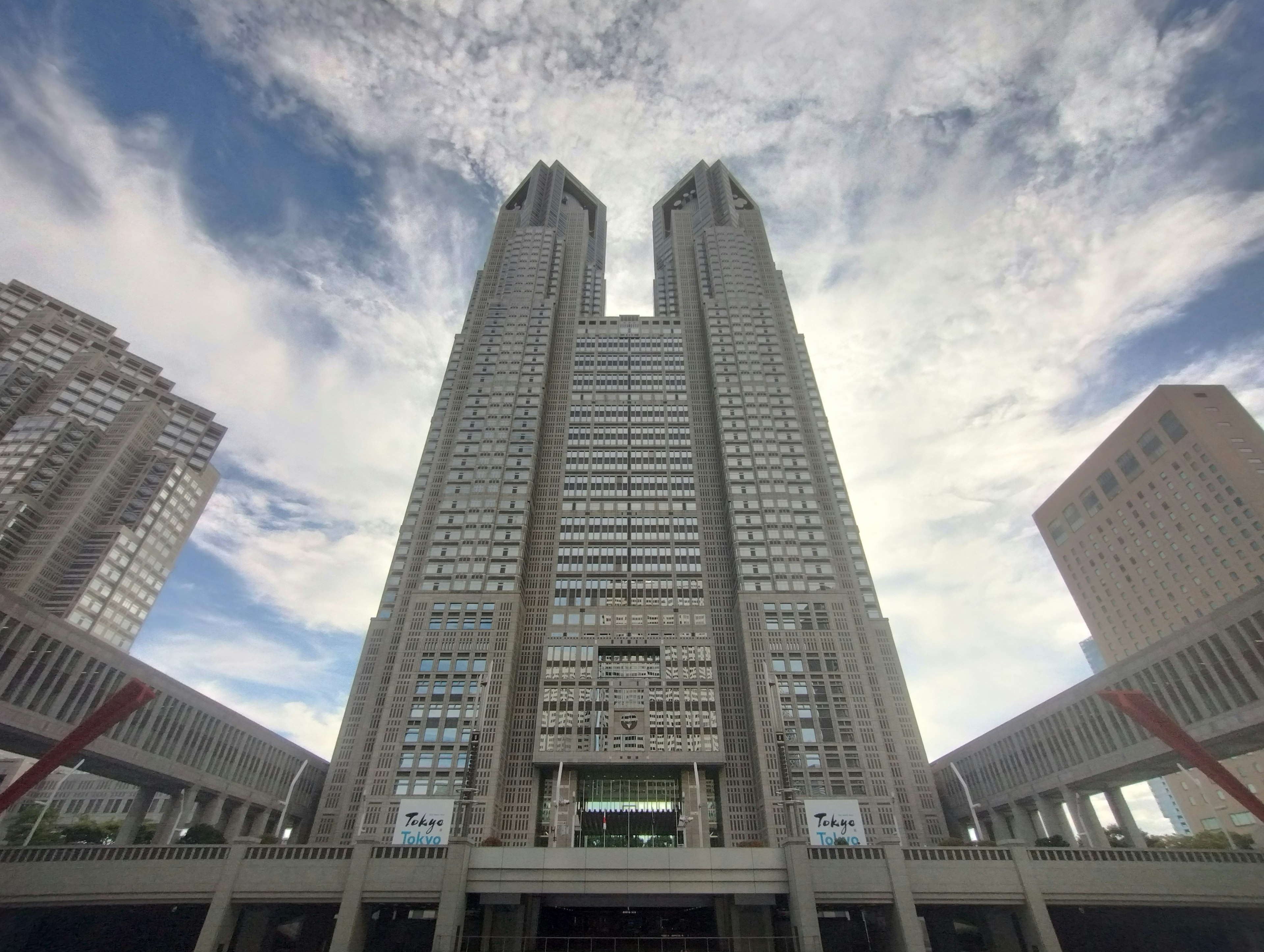 東京都庁の高層ビルが青空の下に立つ