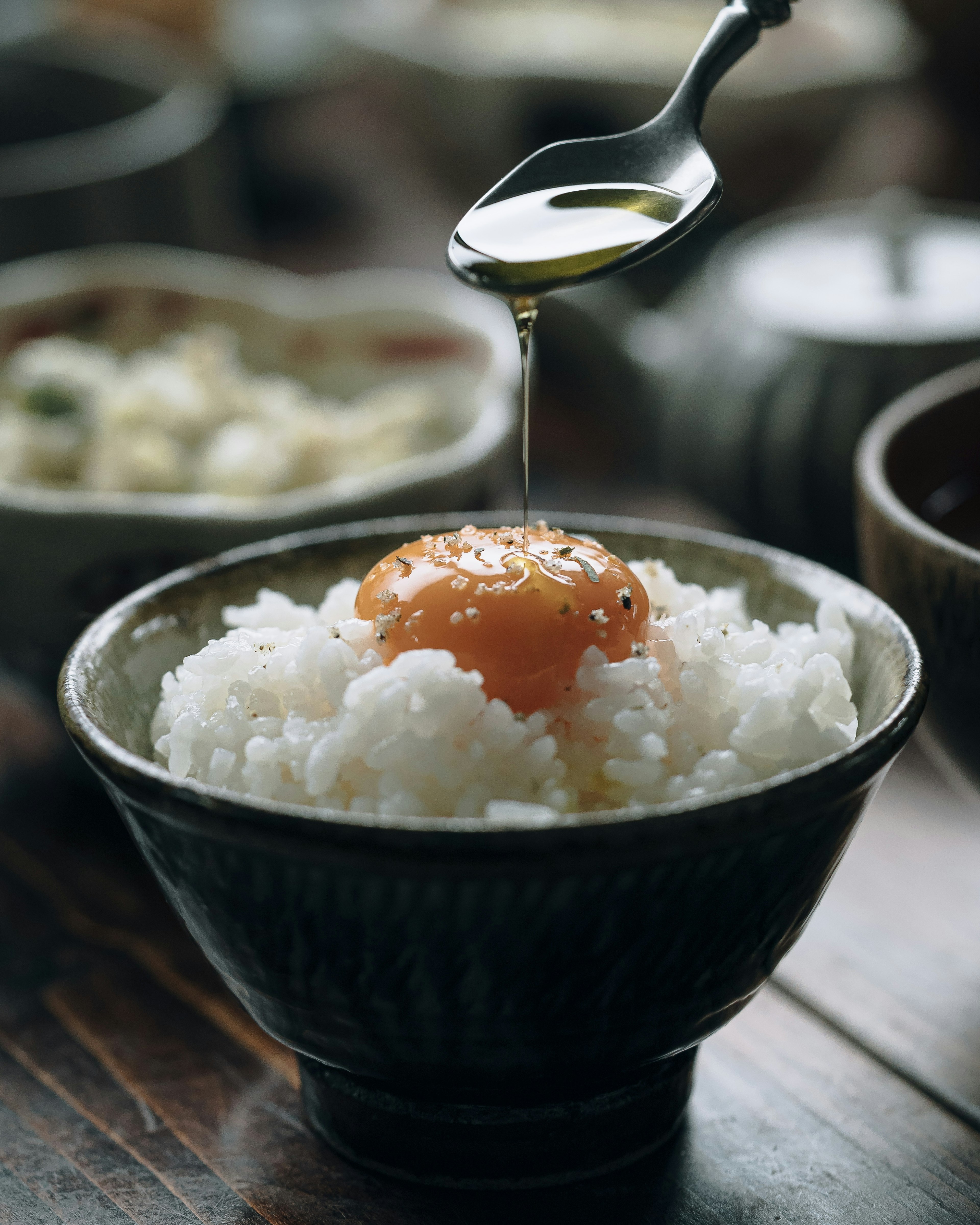 Un tazón de arroz blanco con una yema de huevo y rociado con aceite de oliva