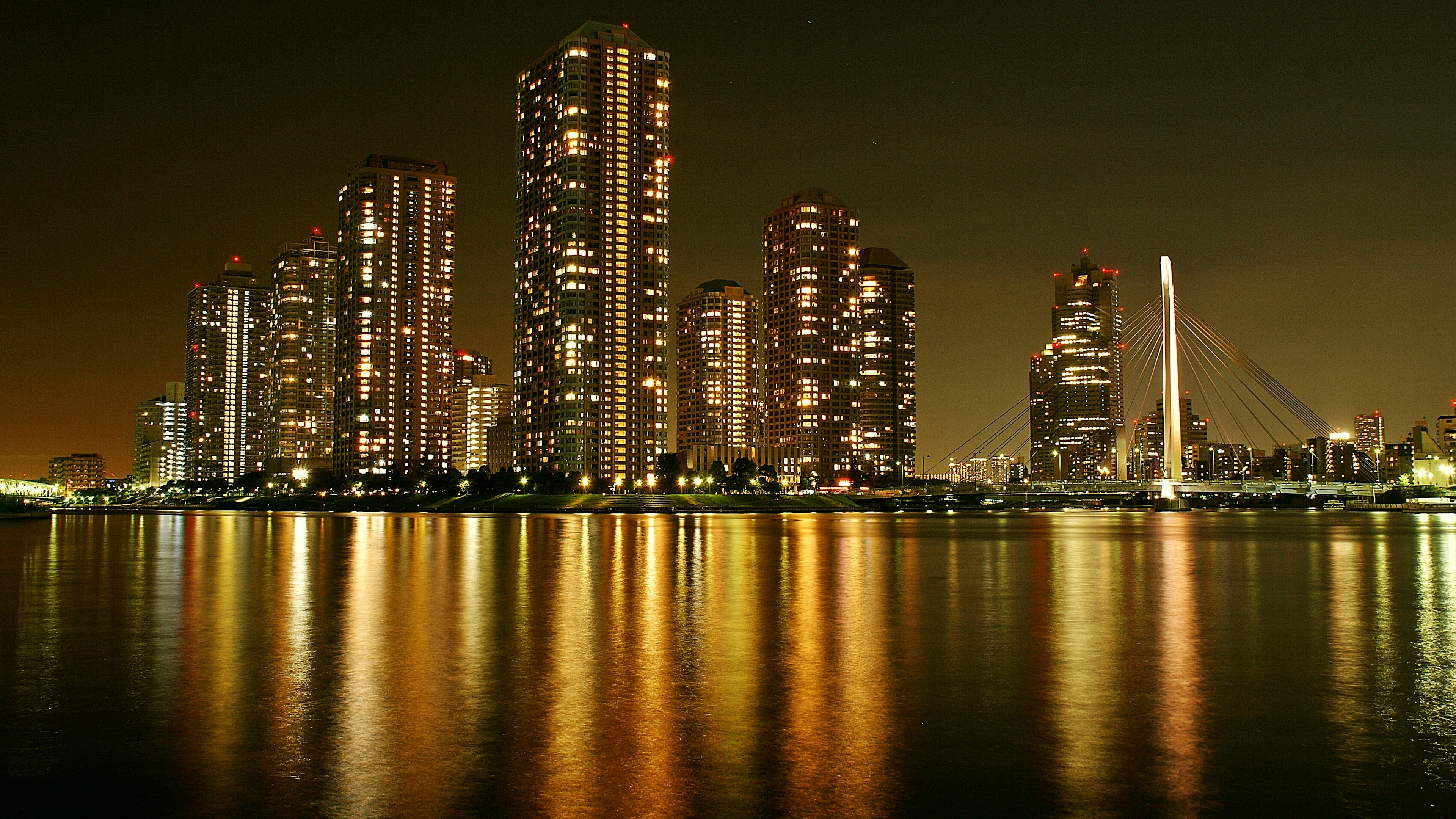 Beeindruckende Skyline von Hochhäusern, die sich nachts im Wasser spiegeln