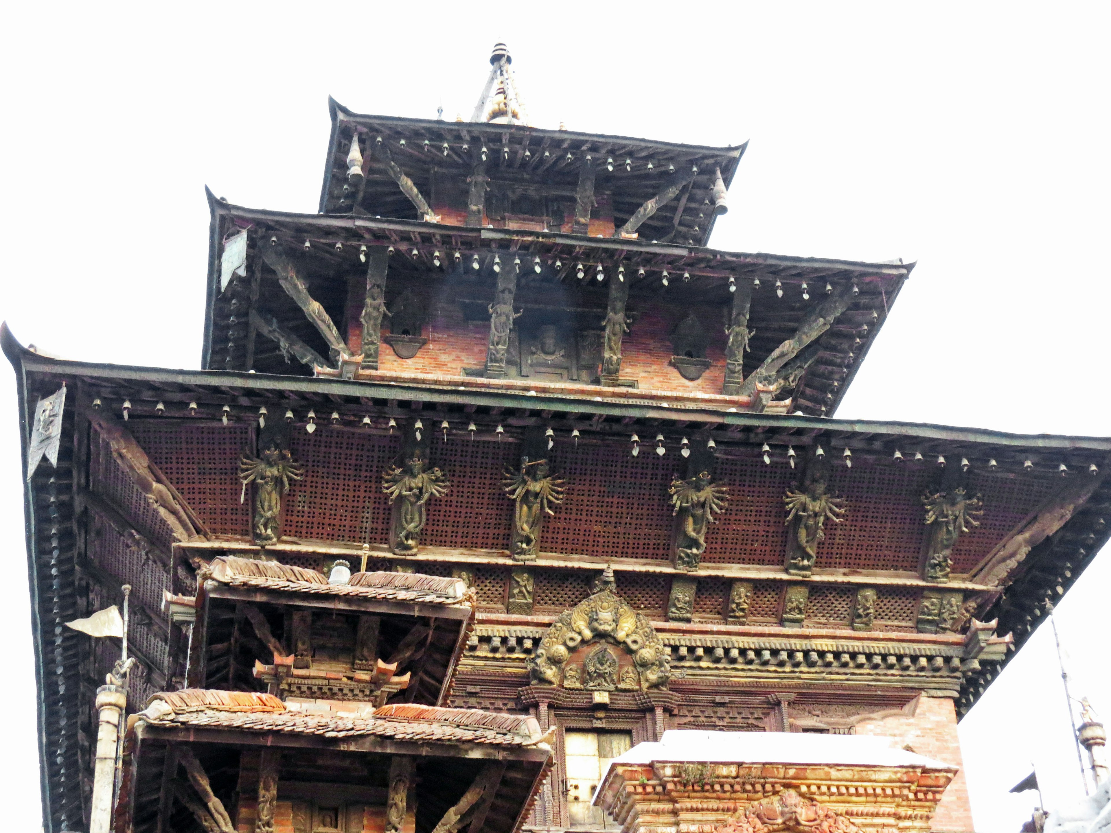 Image d'un temple népalais traditionnel mettant en valeur des sculptures complexes et des structures de toiture décoratives