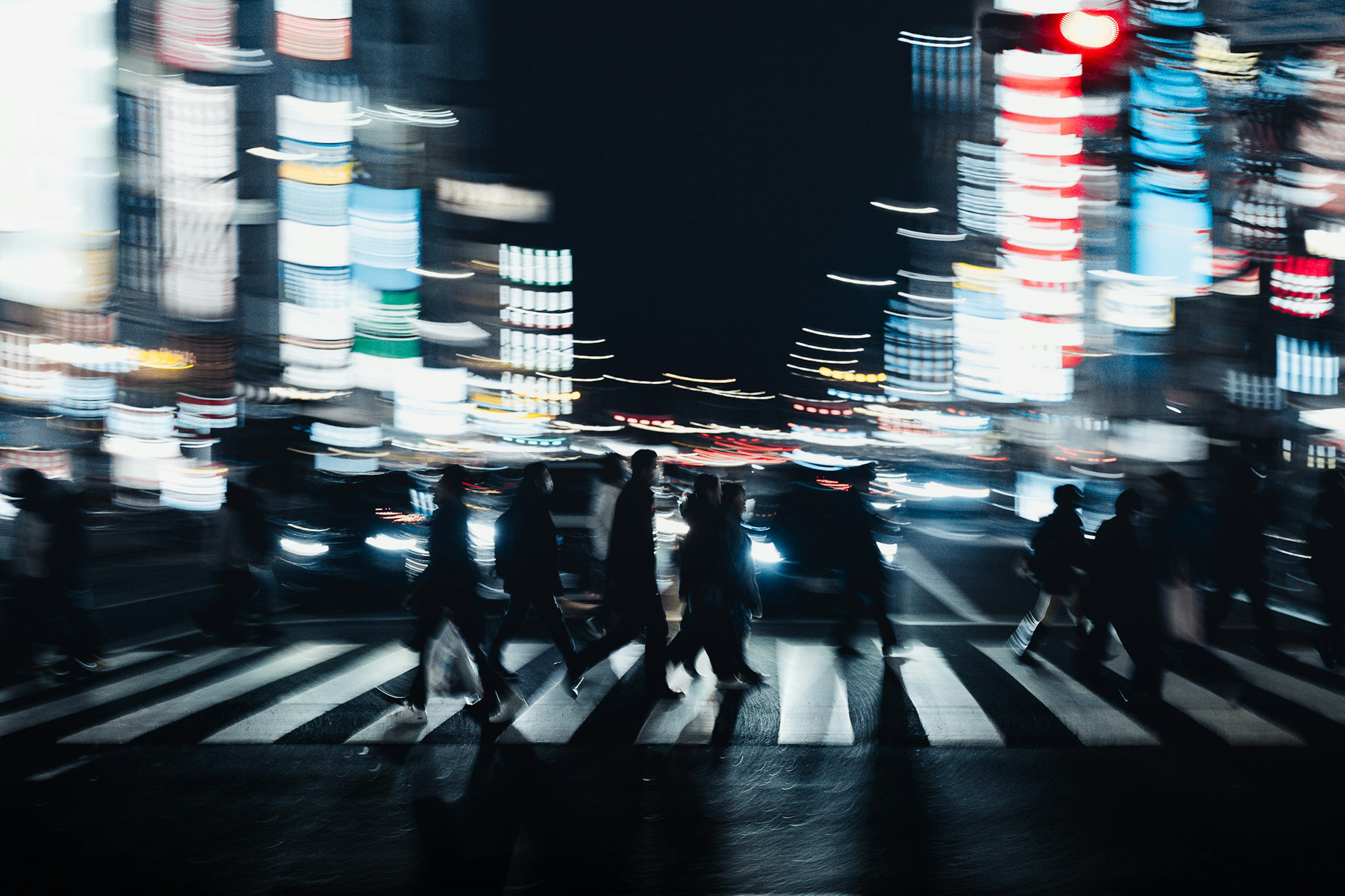 夜の街を歩く人々と明るいネオンの光