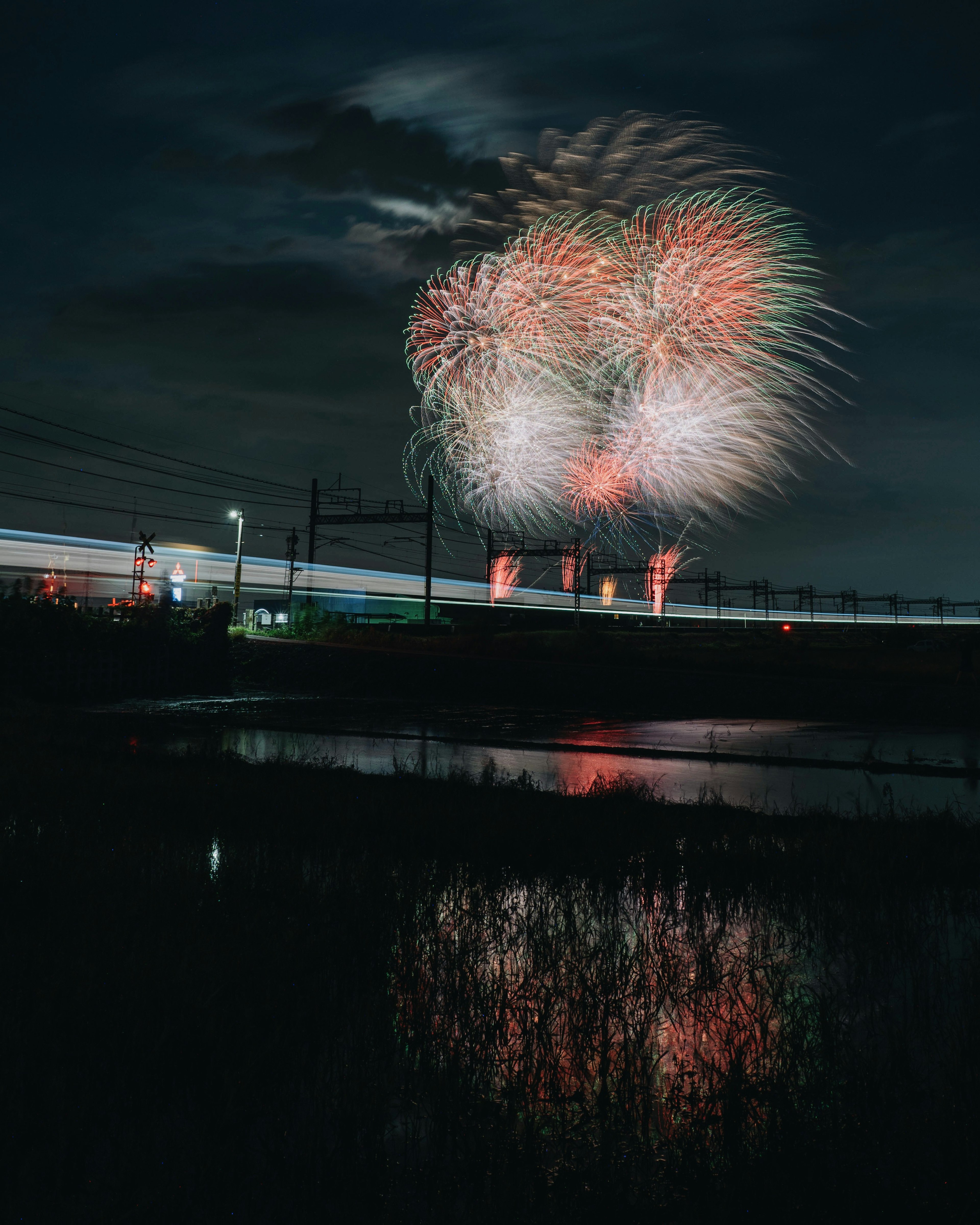 夜空に打ち上げられた花火が水面に映る美しい風景