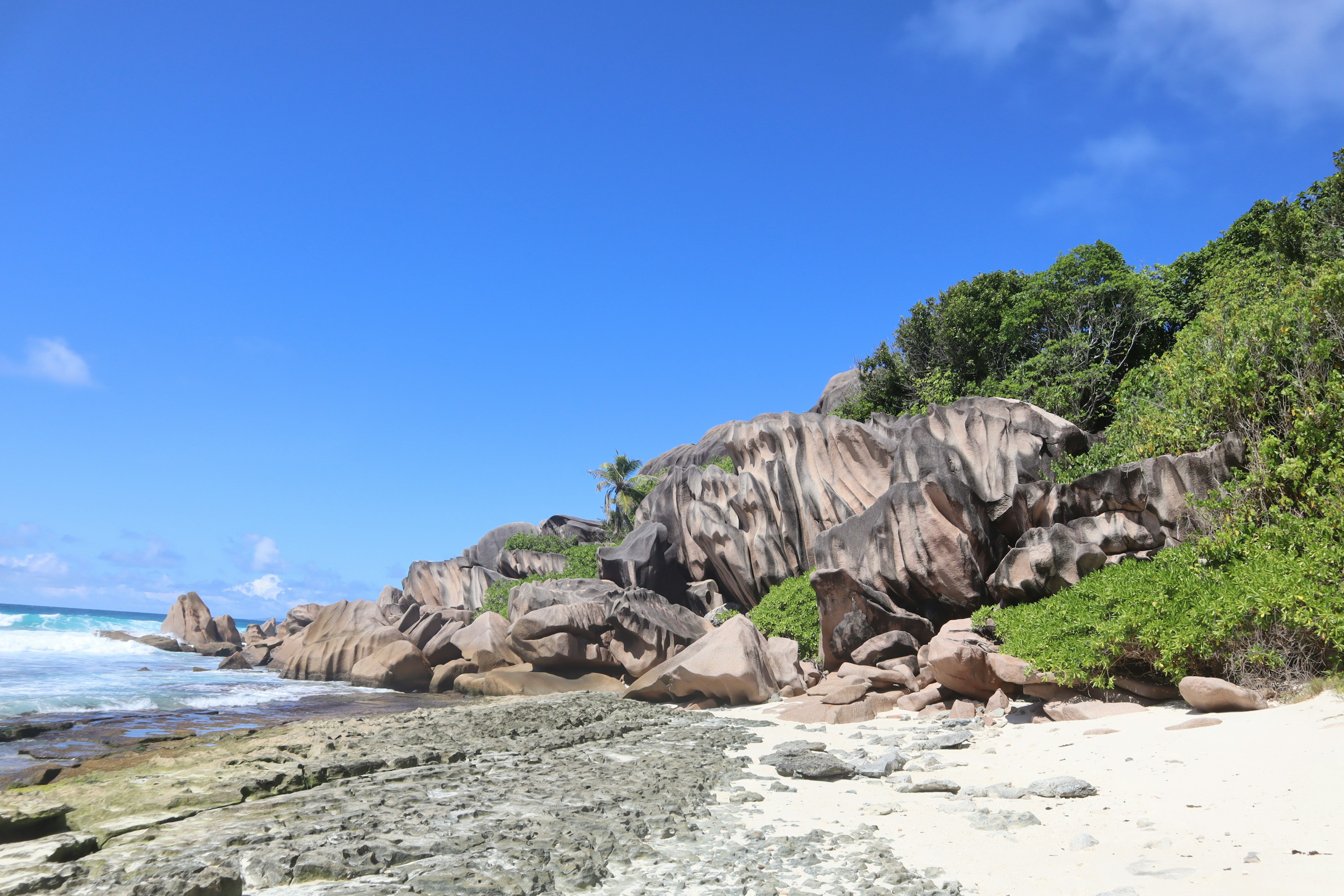 Vista panoramica della spiaggia con cielo blu e scogliere rocciose