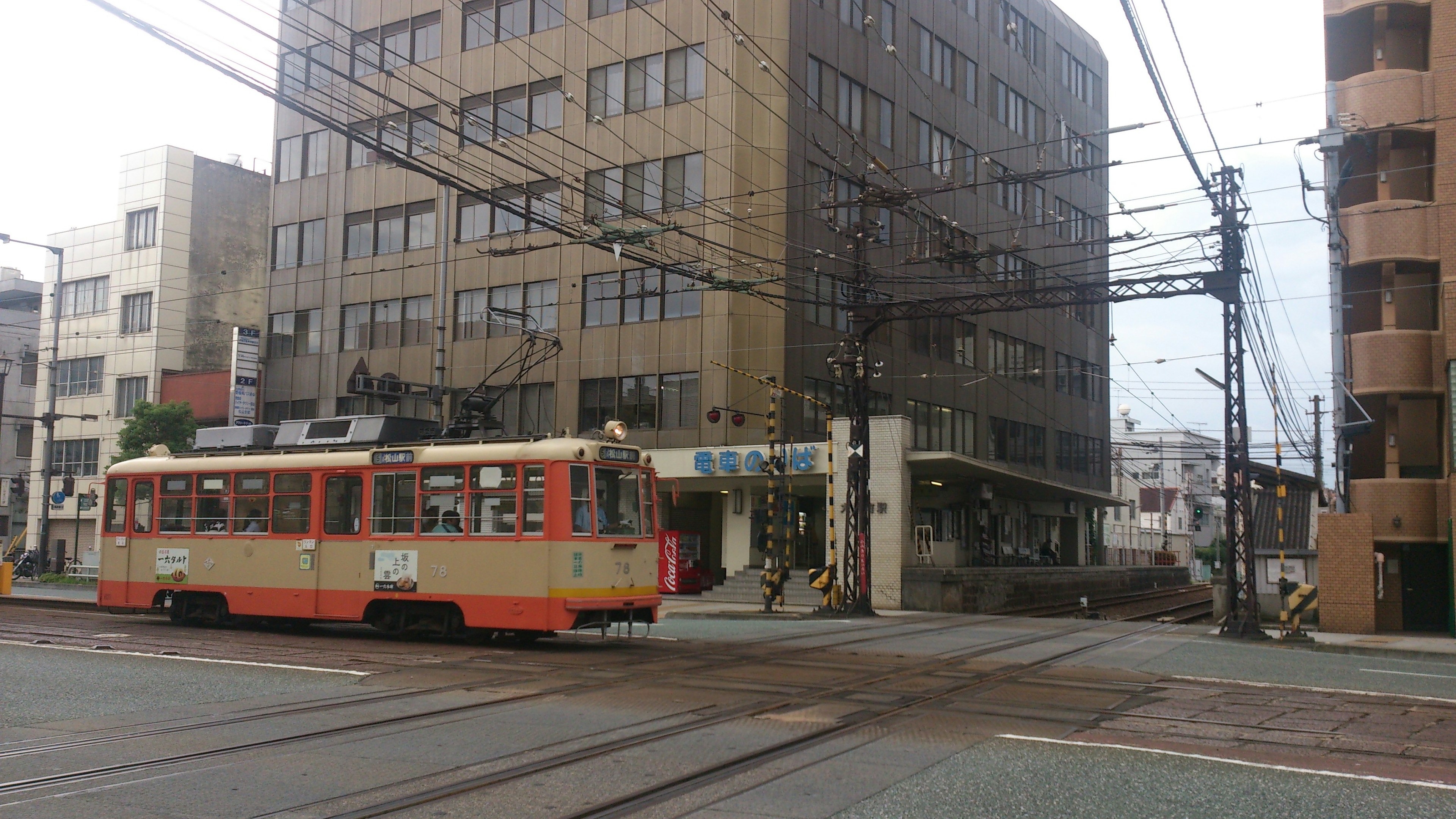 Blick auf eine orange Straßenbahn, die eine Kreuzung überquert