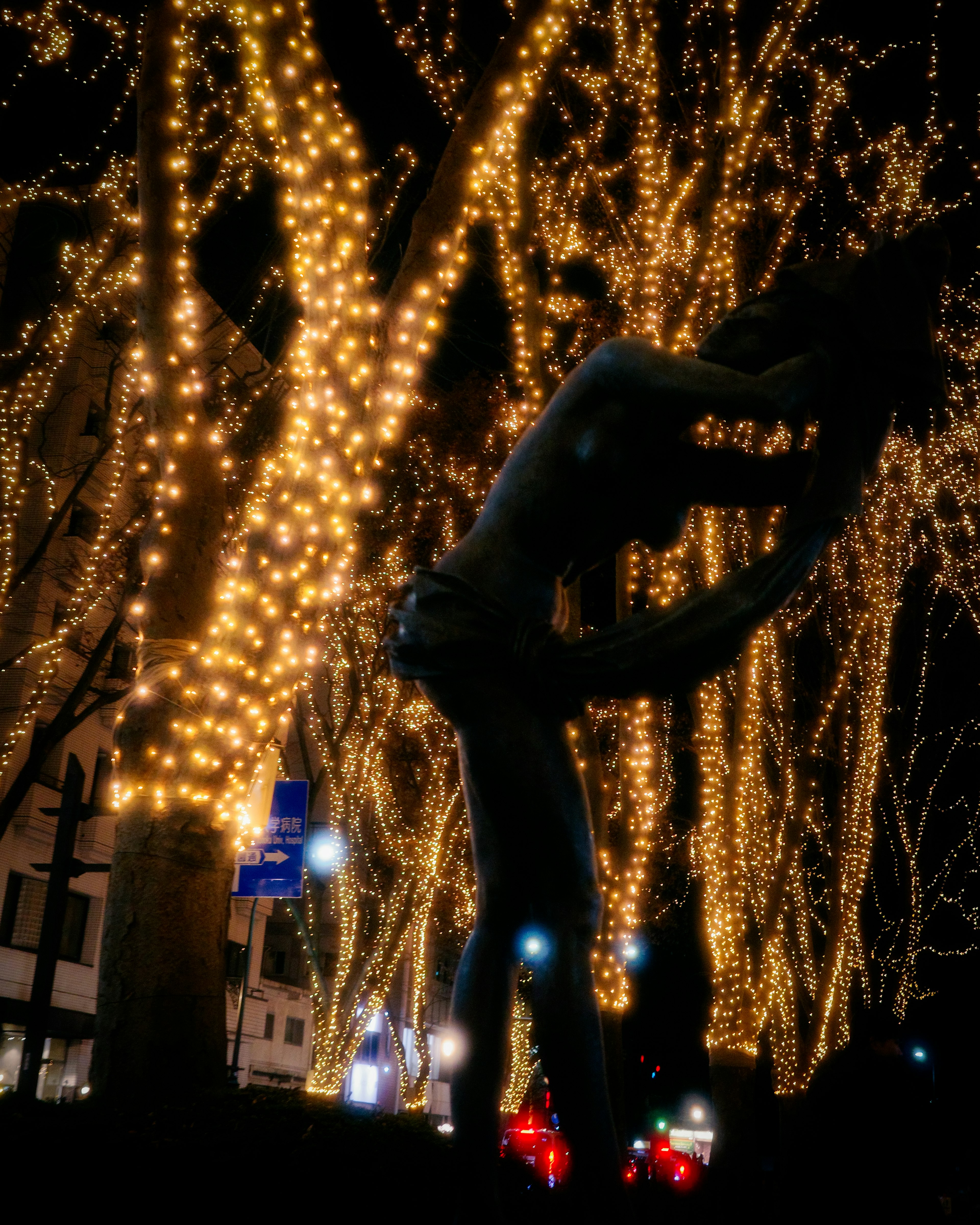 Silueta de una pareja besándose rodeada de luces brillantes en un entorno urbano nocturno