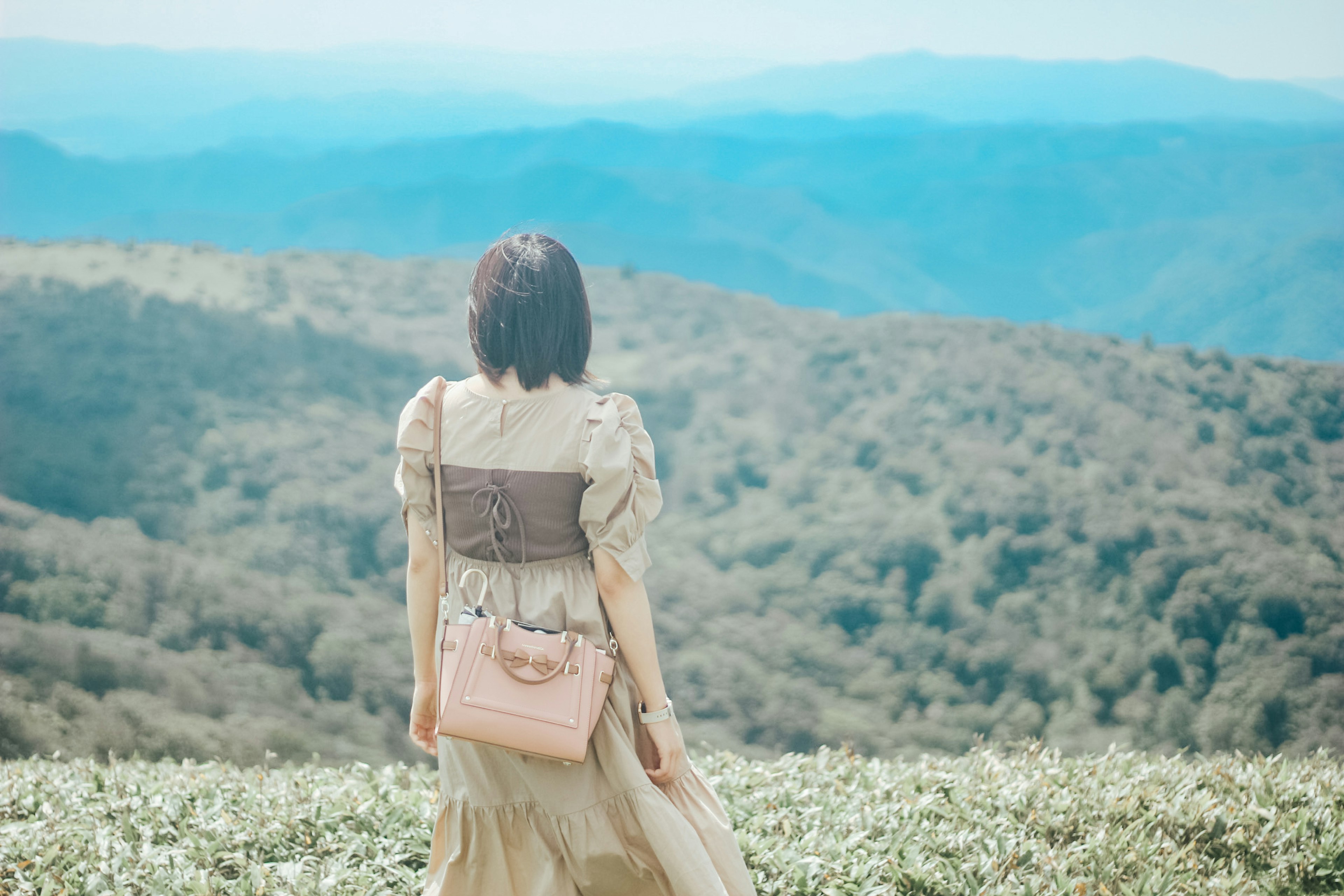 산 풍경을 배경으로 서 있는 여성